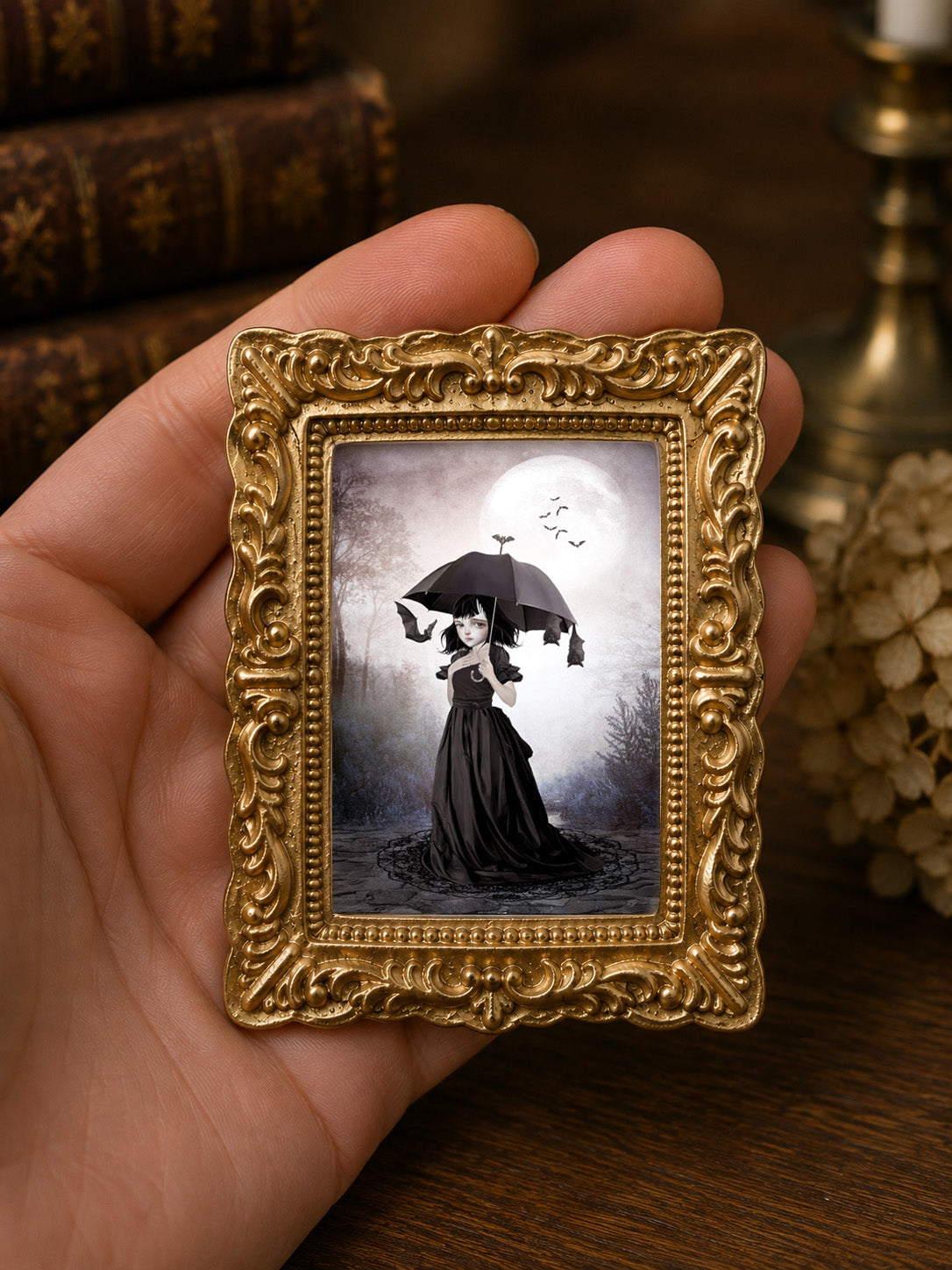 1:12 scale dollhouse miniature painting of a dark whimsical goth girl with a parasol and bats under a pale full moon, framed in antique gold decor.