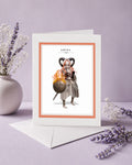 Aries zodiac birthday card featuring an illustration of a white and orange-haired warrior maiden with ram horns holding a flaming bronze shield.