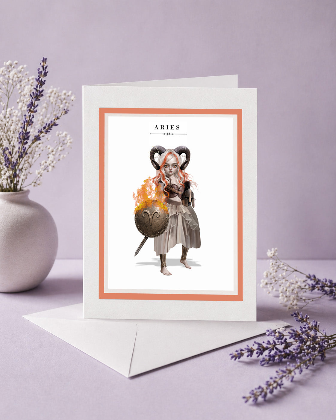 Aries zodiac birthday card featuring an illustration of a white and orange-haired warrior maiden with ram horns holding a flaming bronze shield.