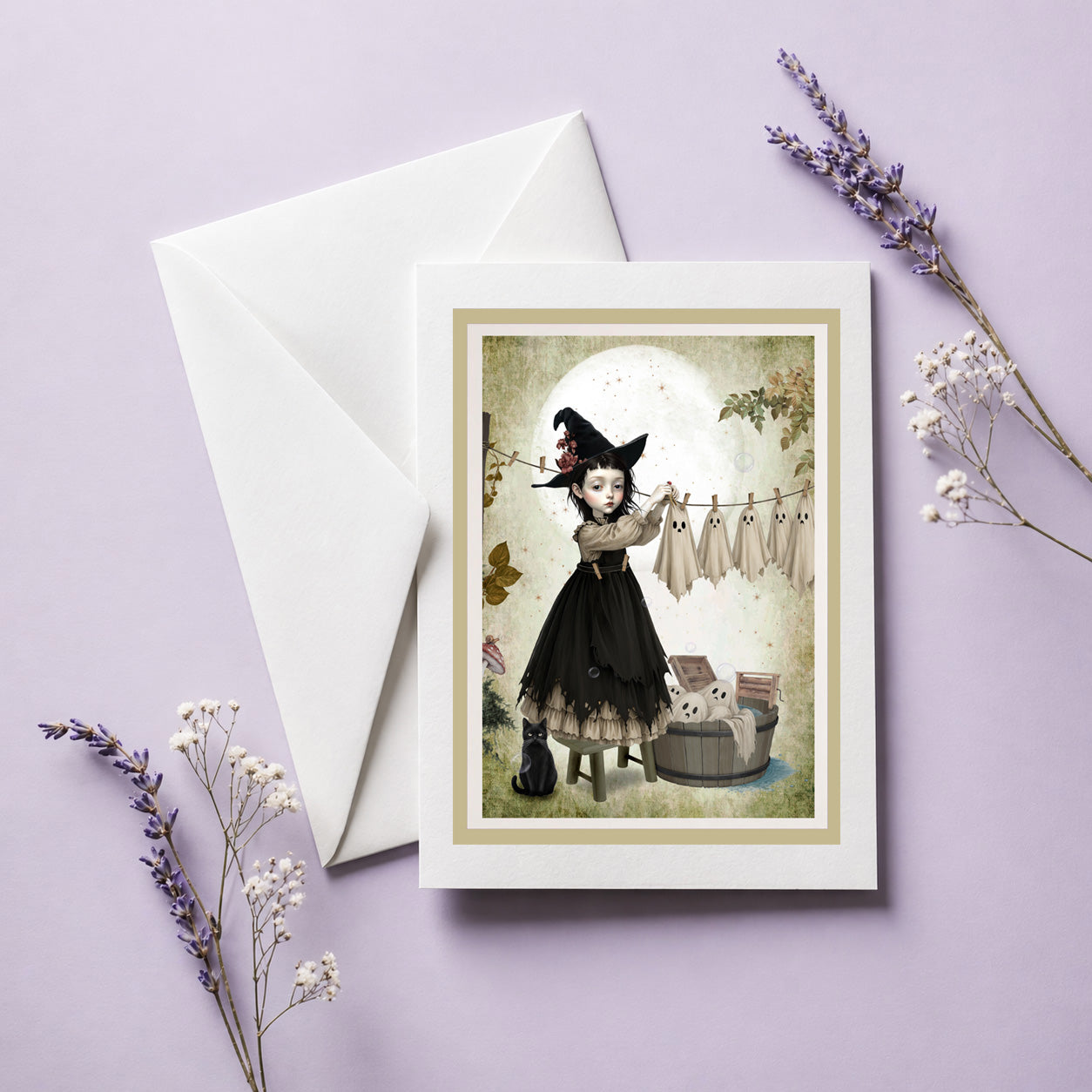 Blank frameable art greeting card and envelope featuring a gothic witch girl hanging sheet ghosts on a clothesline.