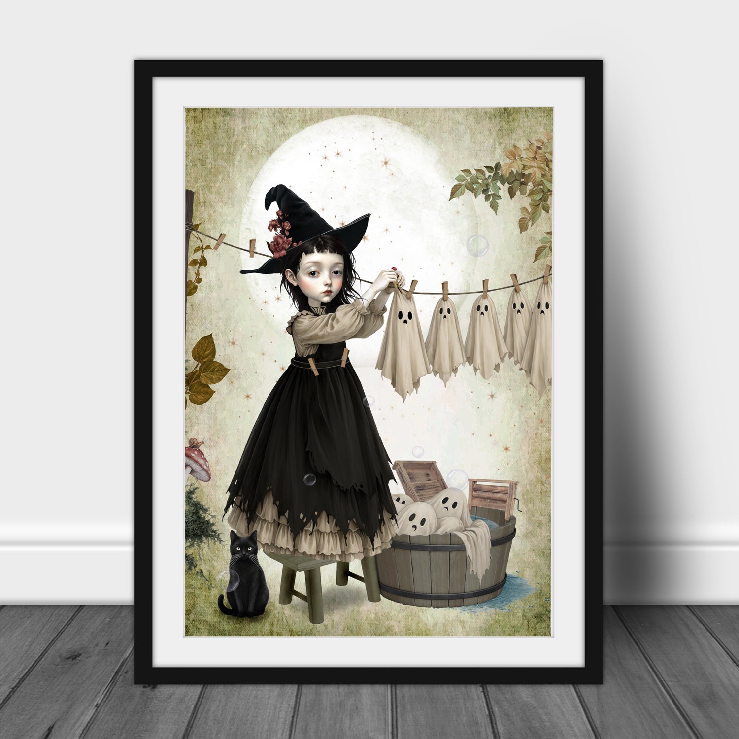 Dark cottagecore autumn art print in A3 Frame. A gothic witch girl in a black hat hanging sheet ghosts on a clothesline with a black cat nearby, 