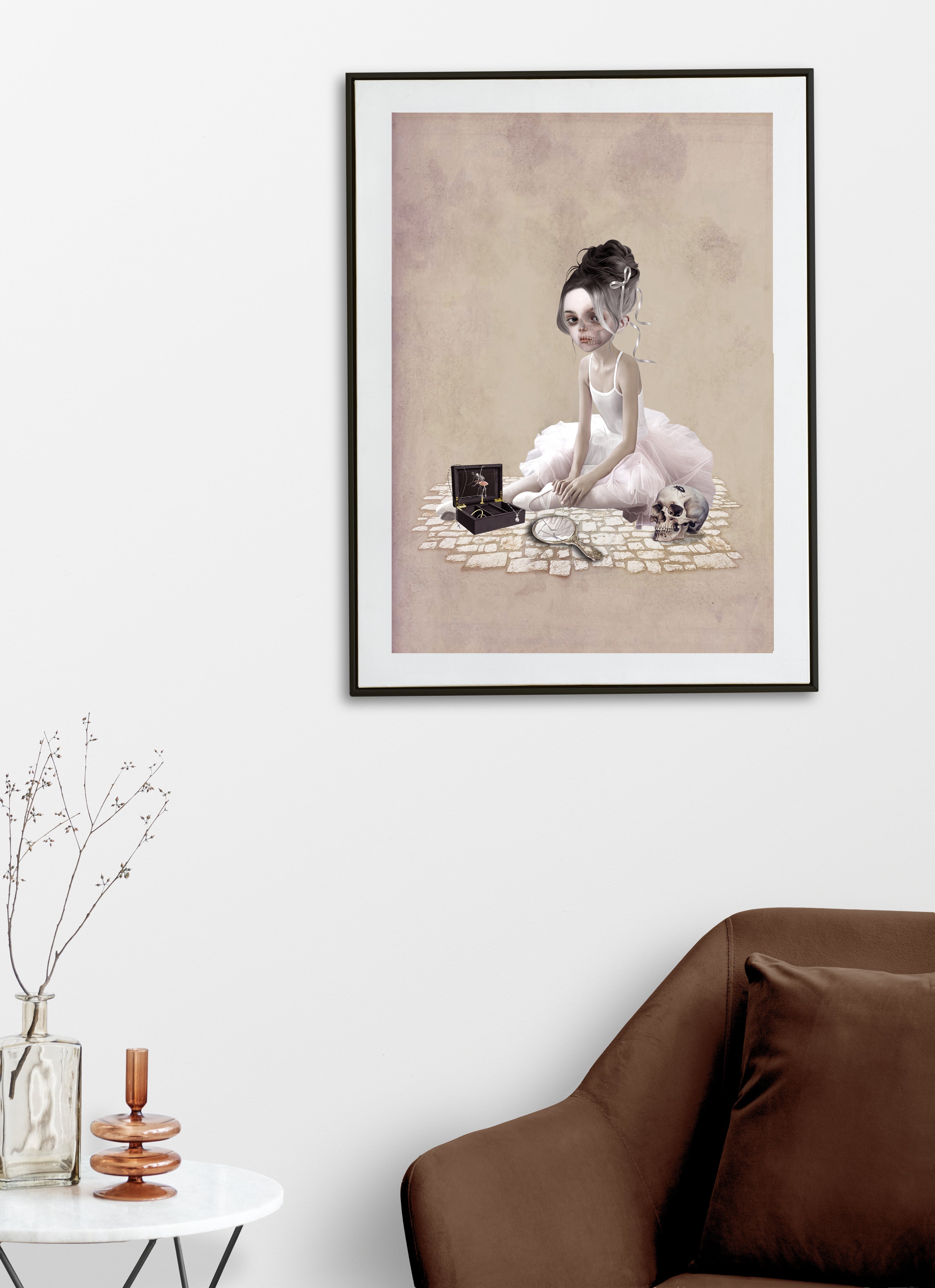 Framed artwork of a gothic ballerina sitting on a brick path with a music box in a living room setting.