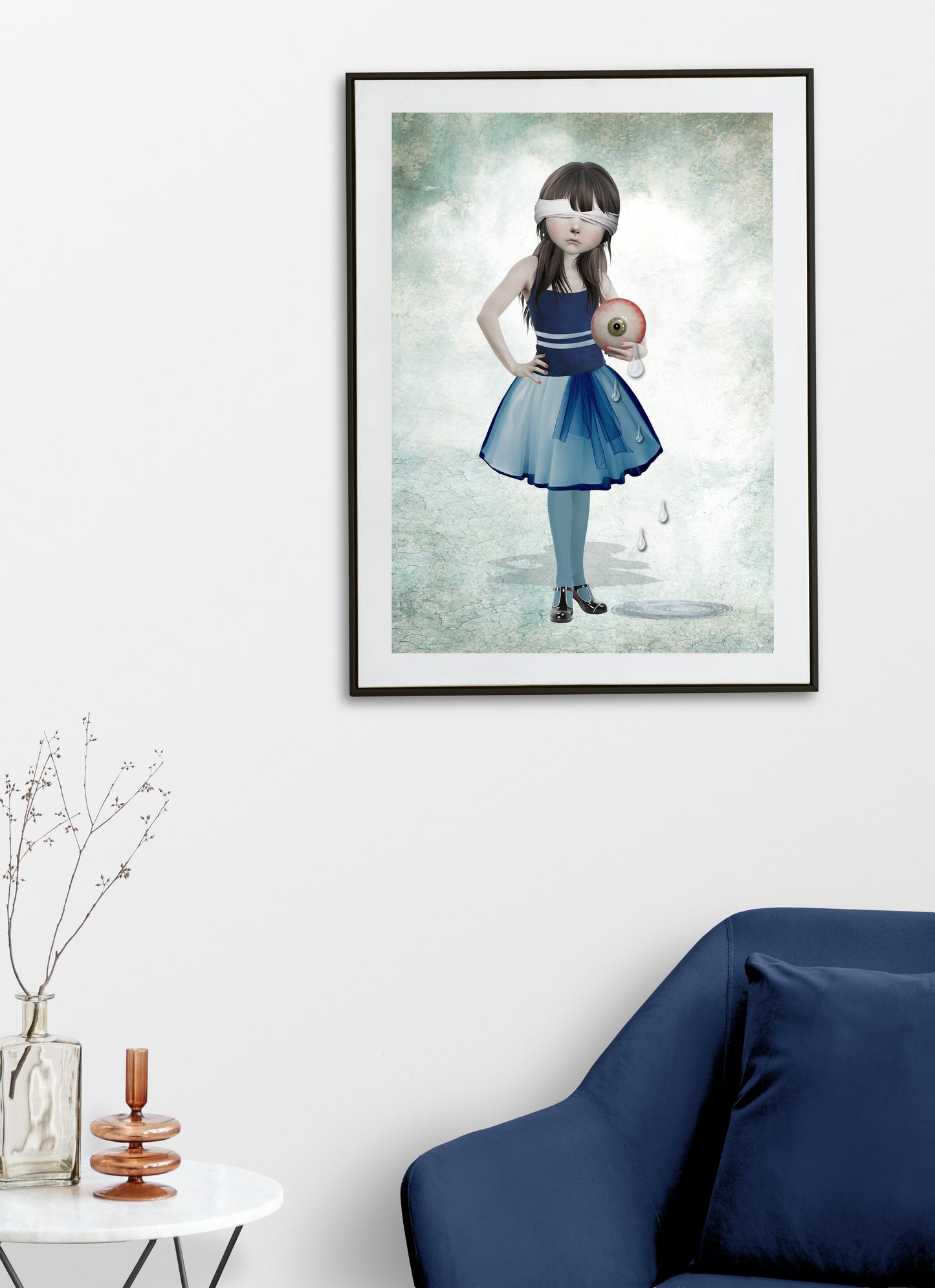 Blindfolded girl and an oversized eyeball art print hanging on the wall of a modern living room. Perfect for adding a weird edgy touch to home decor.
