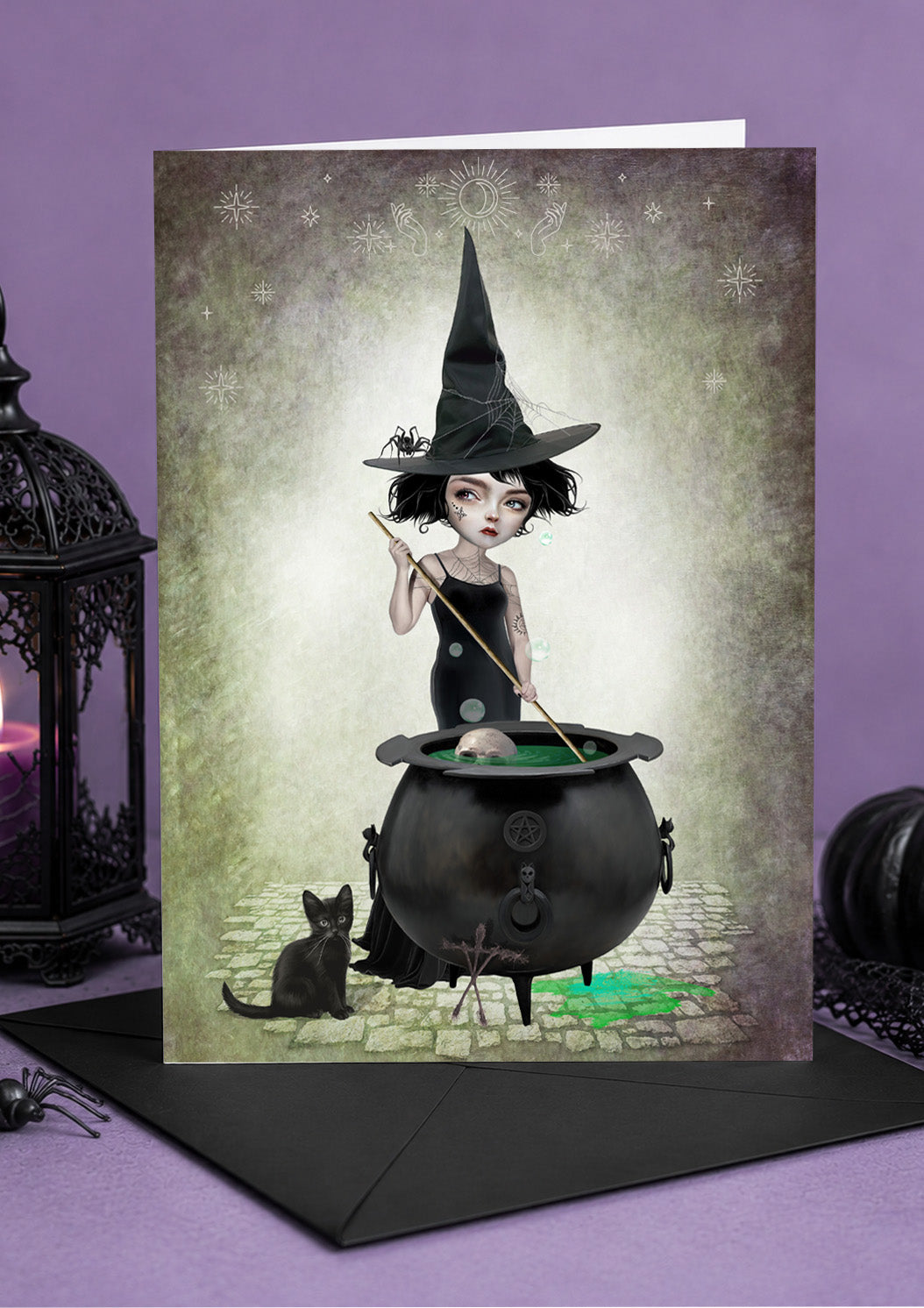 A witch stirring her cauldron alongside her black cat art greeting card.