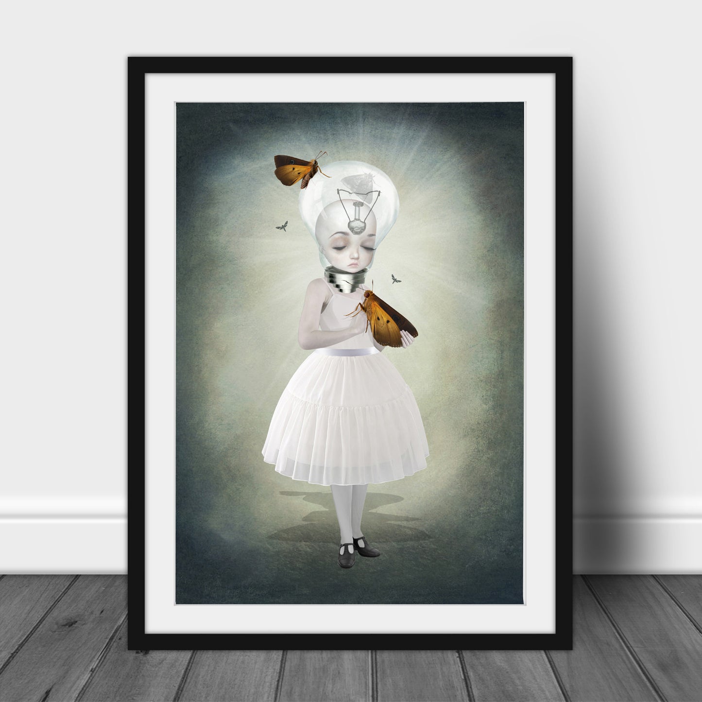Art print of a bulb girl and moths, in a frame, leaned against a wall.
