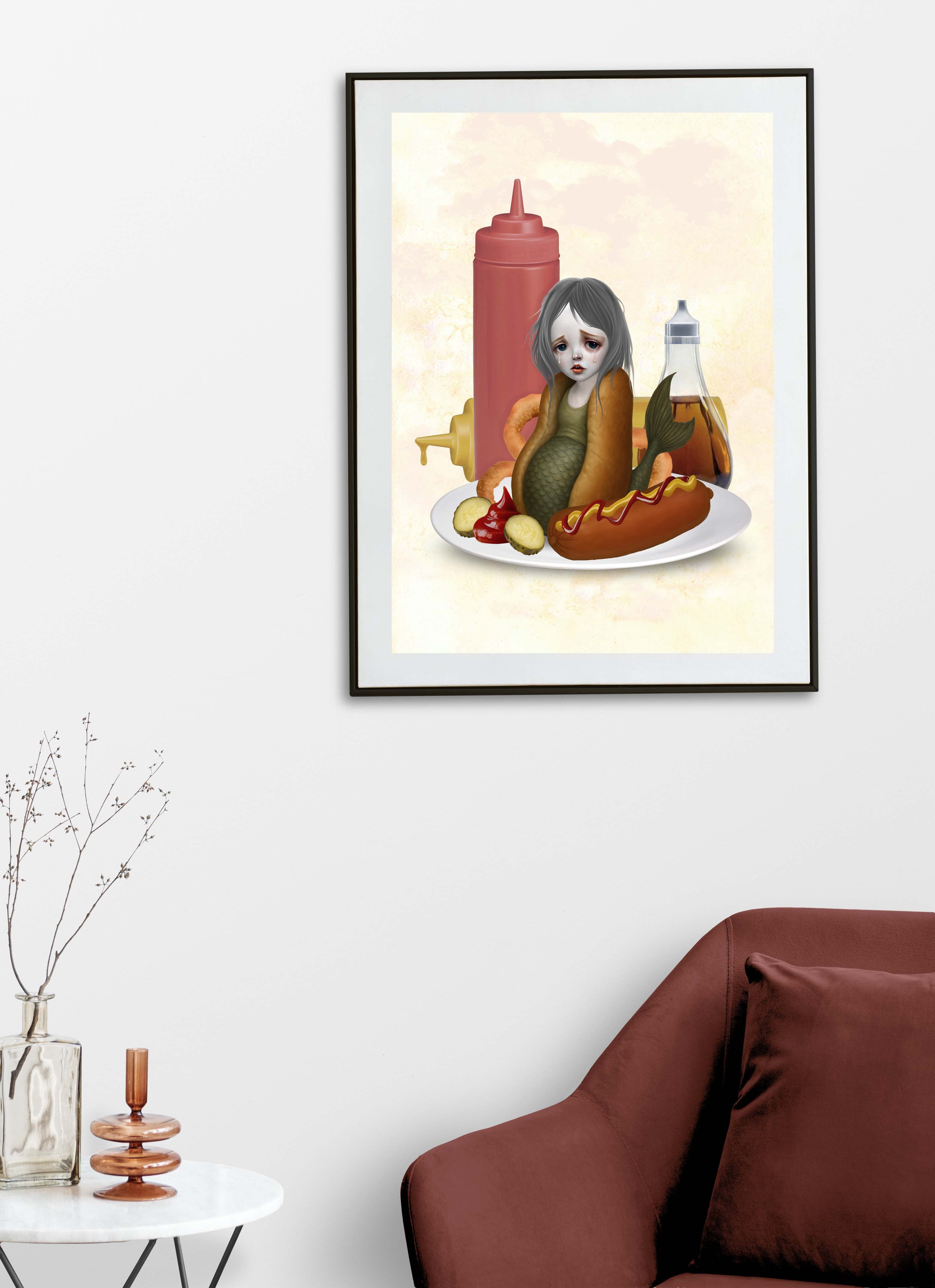 Framed artwork of a sa mermaid with food items on a plate in a living room setting.