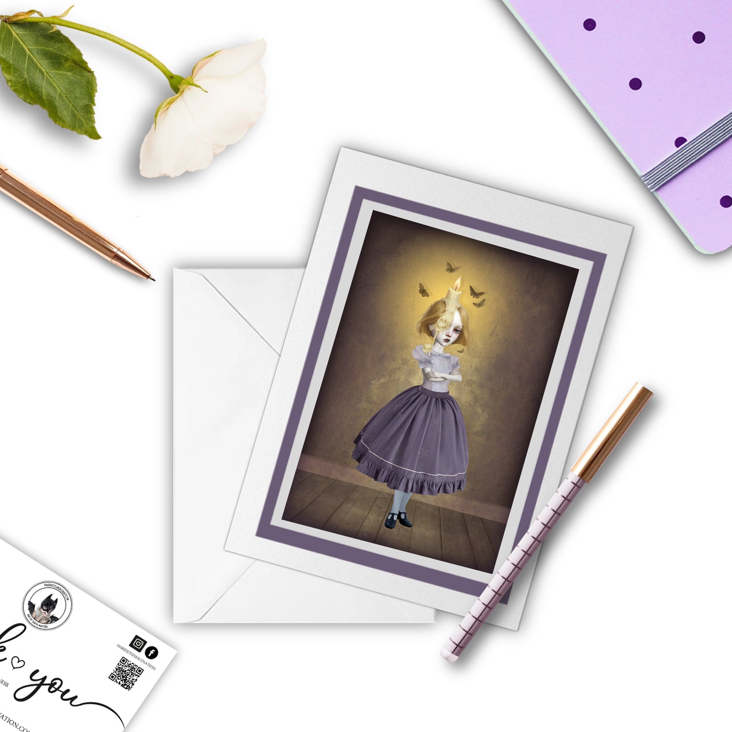 Whimsical Candle Girl greeting card with a notebook and pen, displayed on a flat surface.
