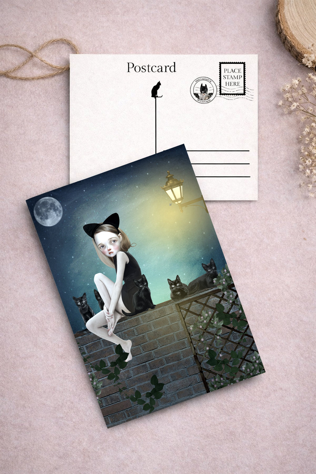 Postcard with a cat-themed design featuring a girl and cats on a wall at night.