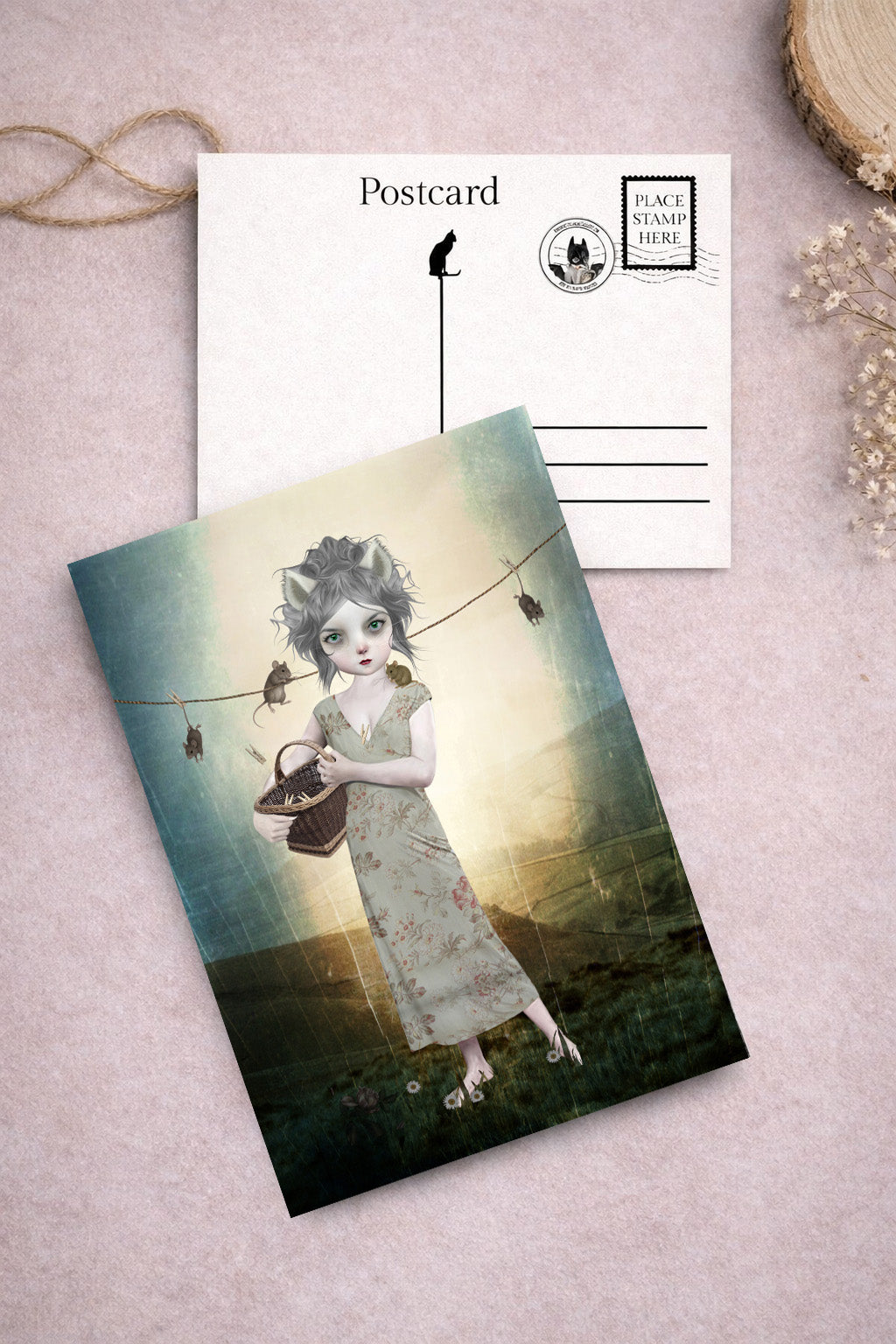 Postcard with artistic illustration of a cat girl in a field and mice on a washine line.