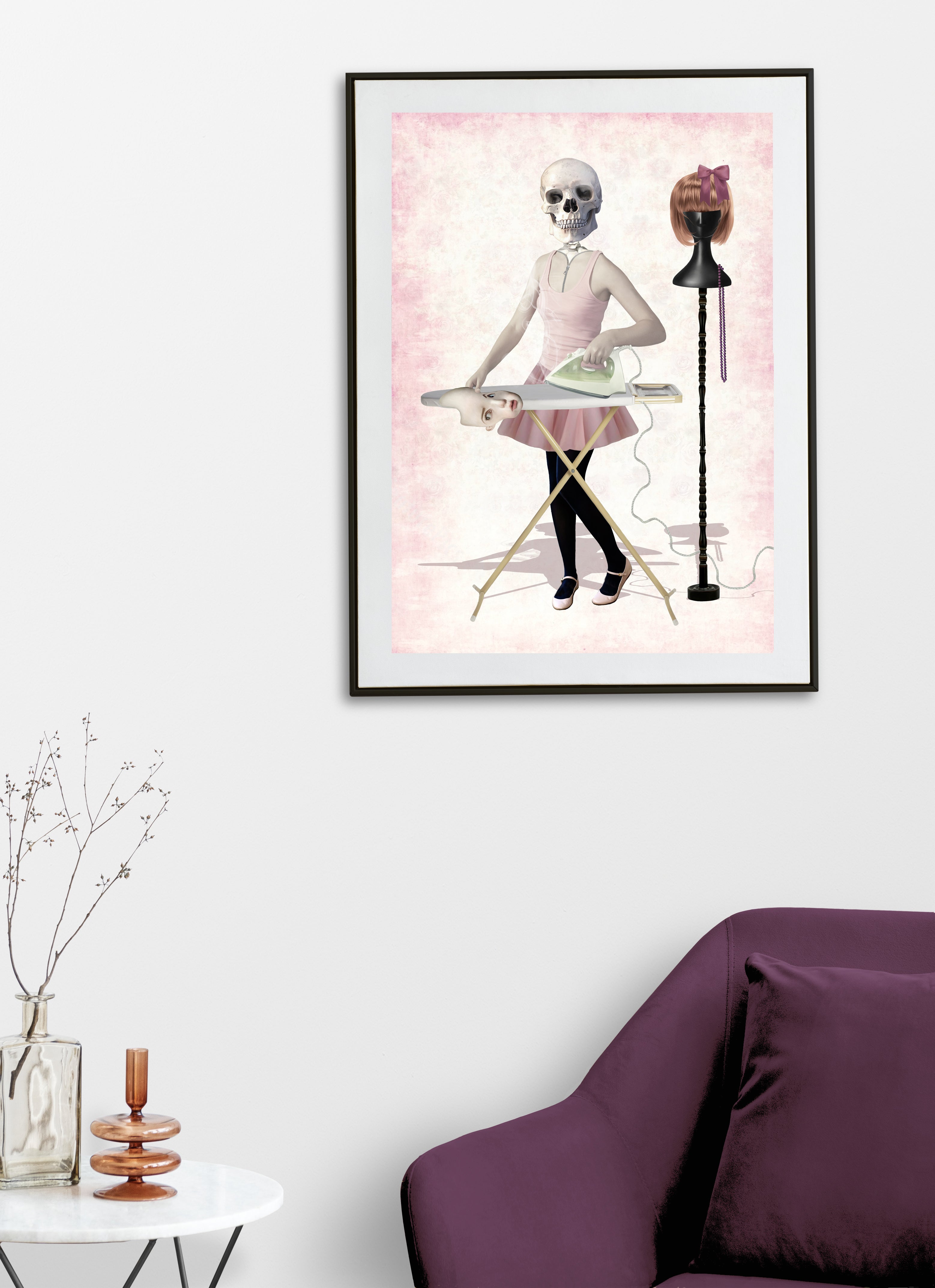 Framed artwork of a skeleton and mannequin on a pink background in a living room setting.
