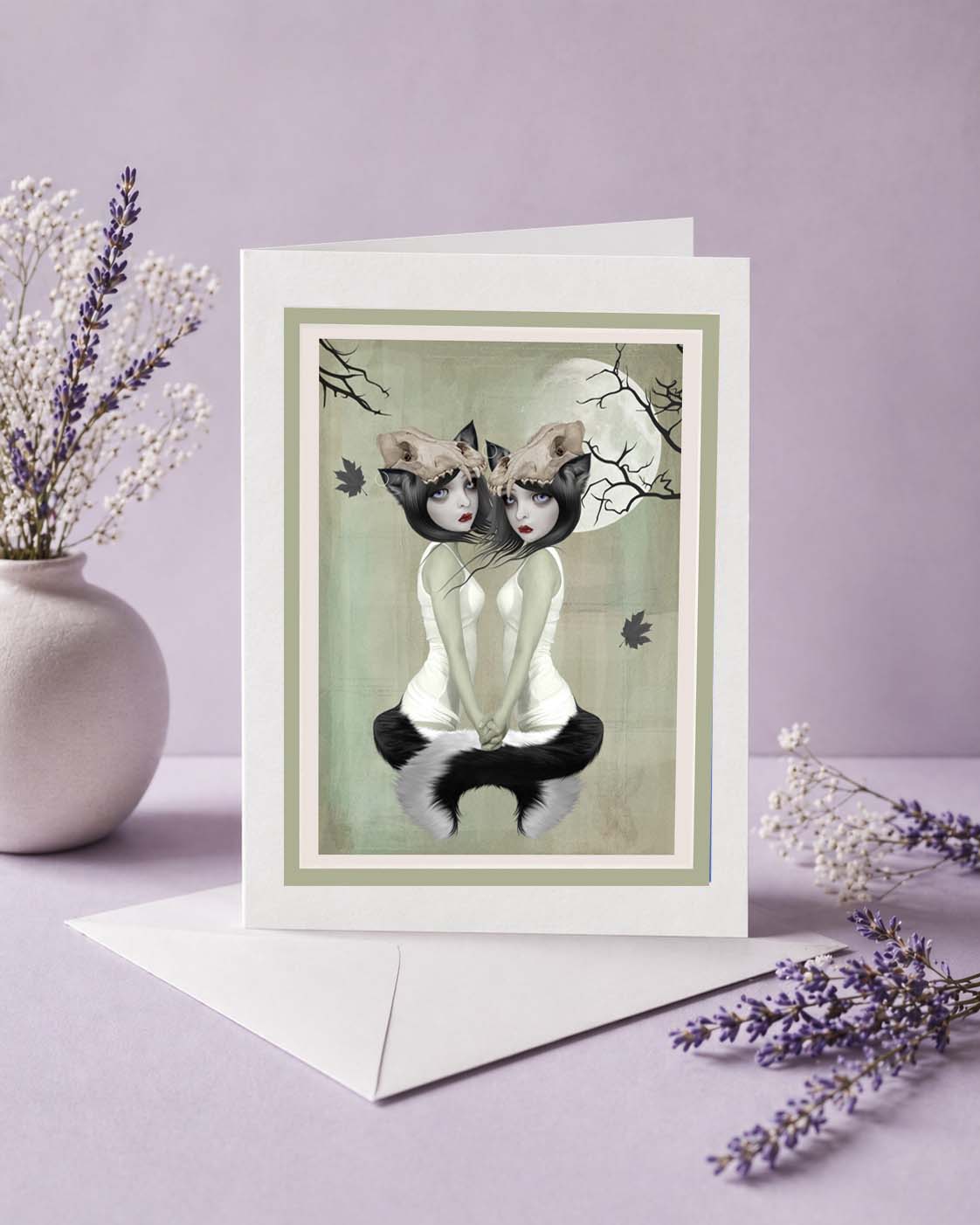 Art greeting card with an illustration of two werewolf sisters beneath the moon, displayed on a purple background.