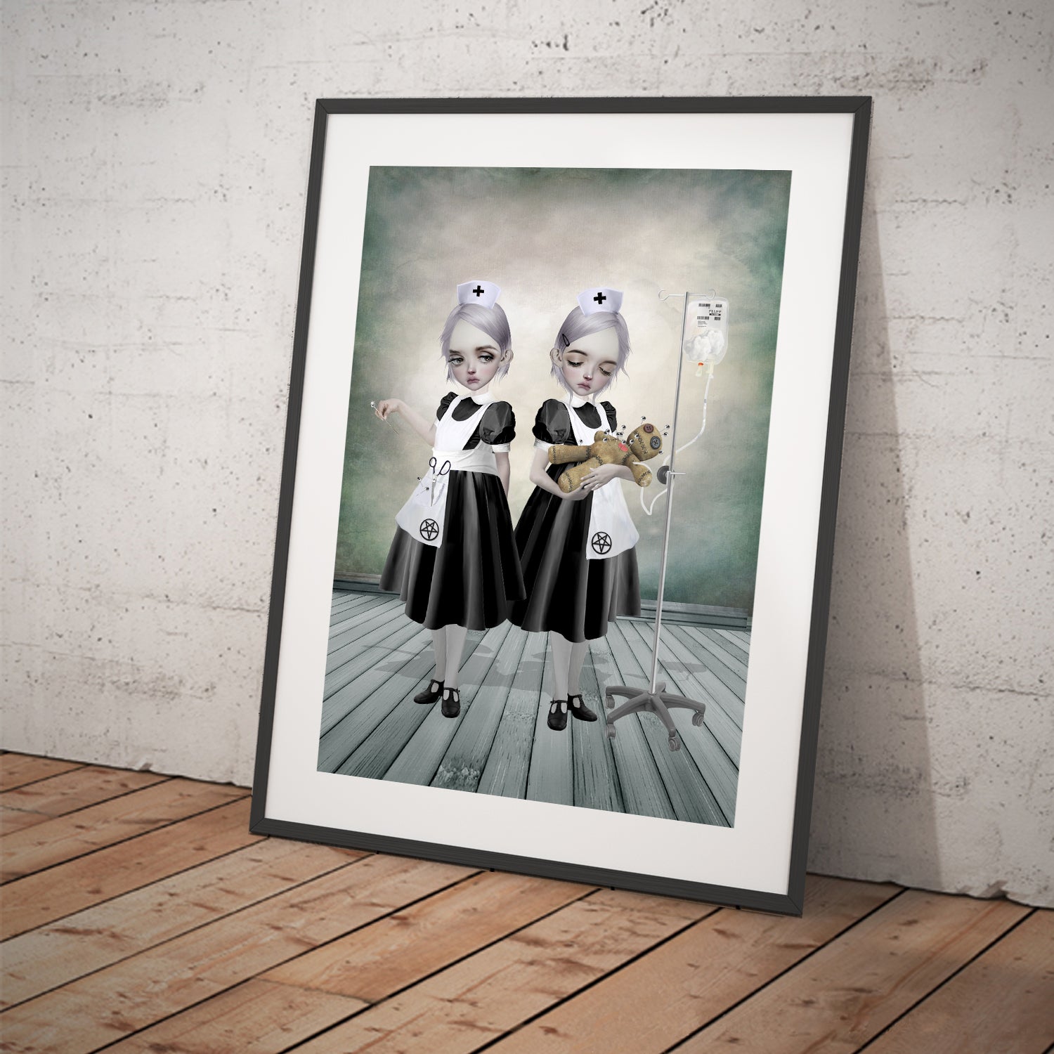 Creepy cute framed art print features two Gothic nurses attending to a voodoo doll. One is inserting pins while the other administers a curious fluff drip. 