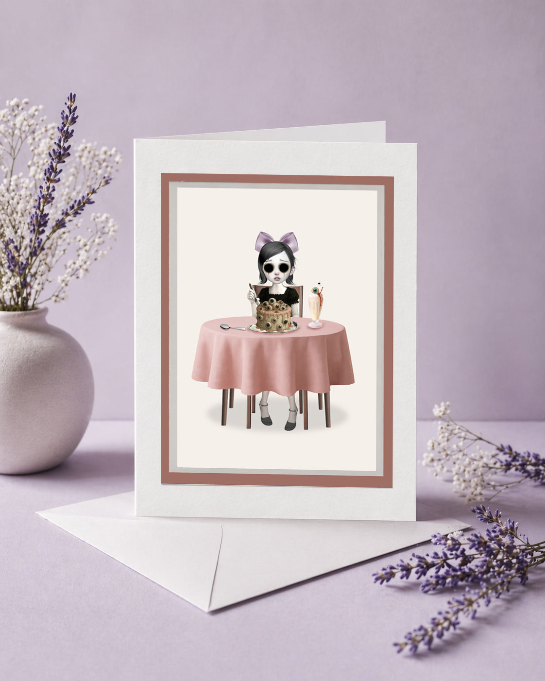 Greeting card with an eyeless girl at a table with eyeball cake on a purple background.
