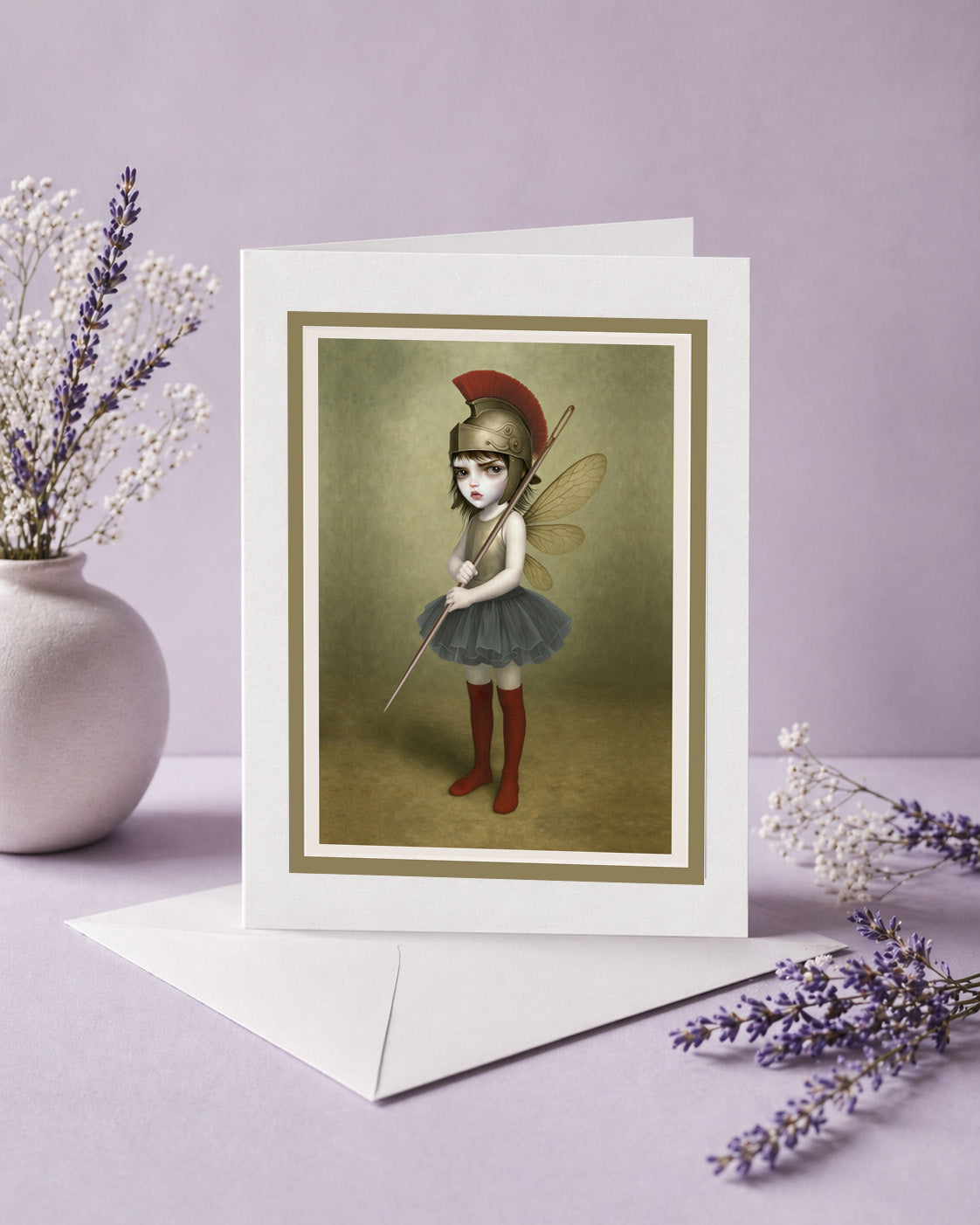 Surreal art greeting card. Featuring a fierce, big-eyed dark fairy dressed as an ancient warrior—complete with a plumed Roman helmet and a sewing needle spear.