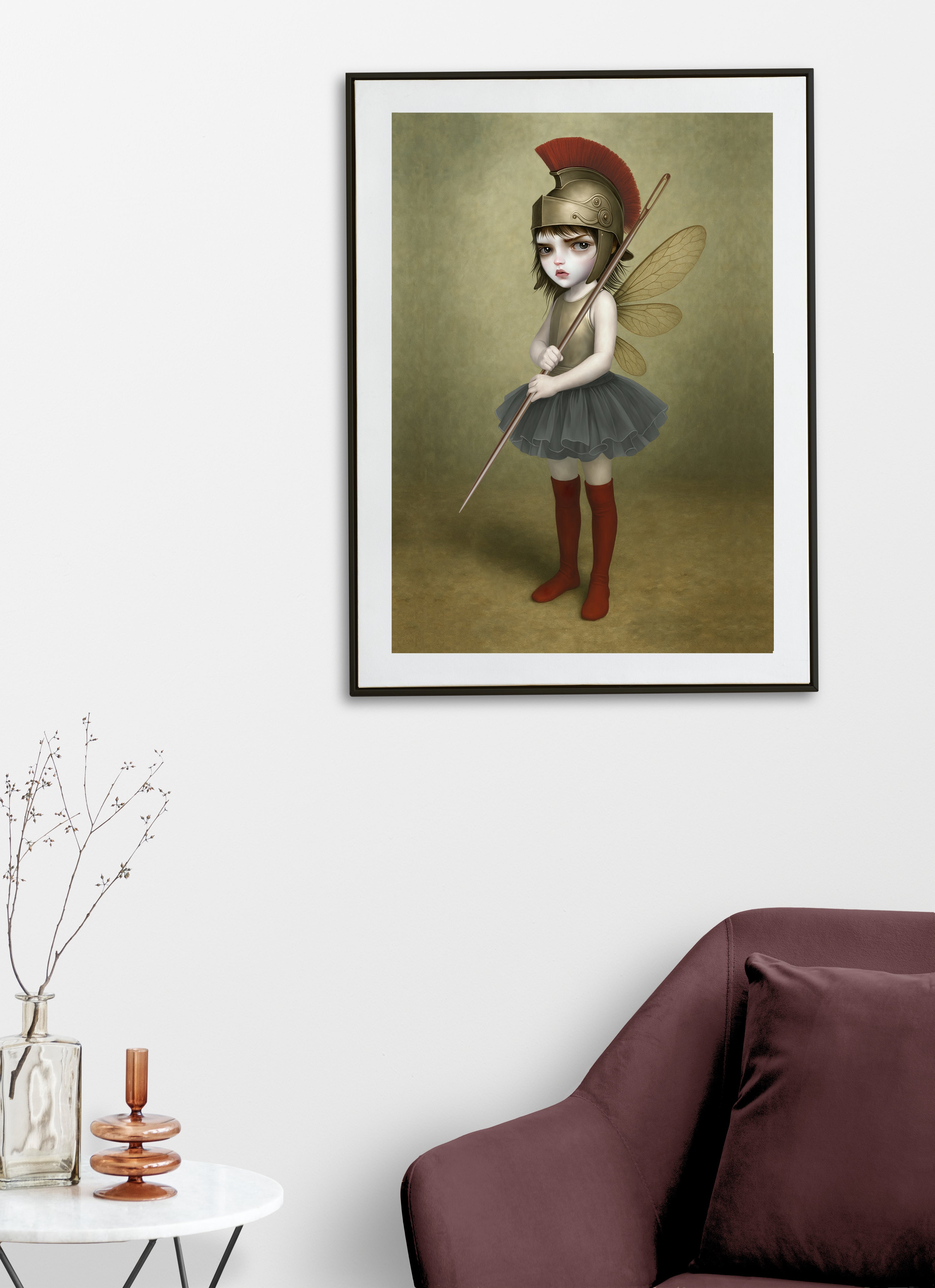 surreal fantasy art print on display on a living room wall features a fierce, big-eyed dark fairy dressed as an ancient warrior. Donning a magnificent Roman-style plumed helmet and holding a sewing needle as a spear.