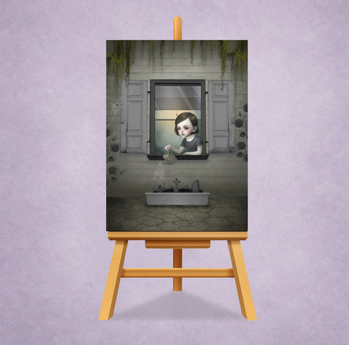 Creepy cute miniature print displayed on a small easel stand featuring a gothic girl watering graves. 