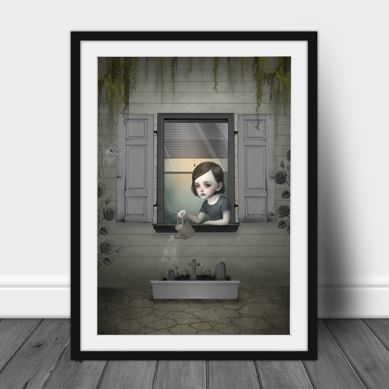 Dark surrealism girl window art print  in an A3 frame featuring a gothic girl watering a miniature graveyard planter with roses.