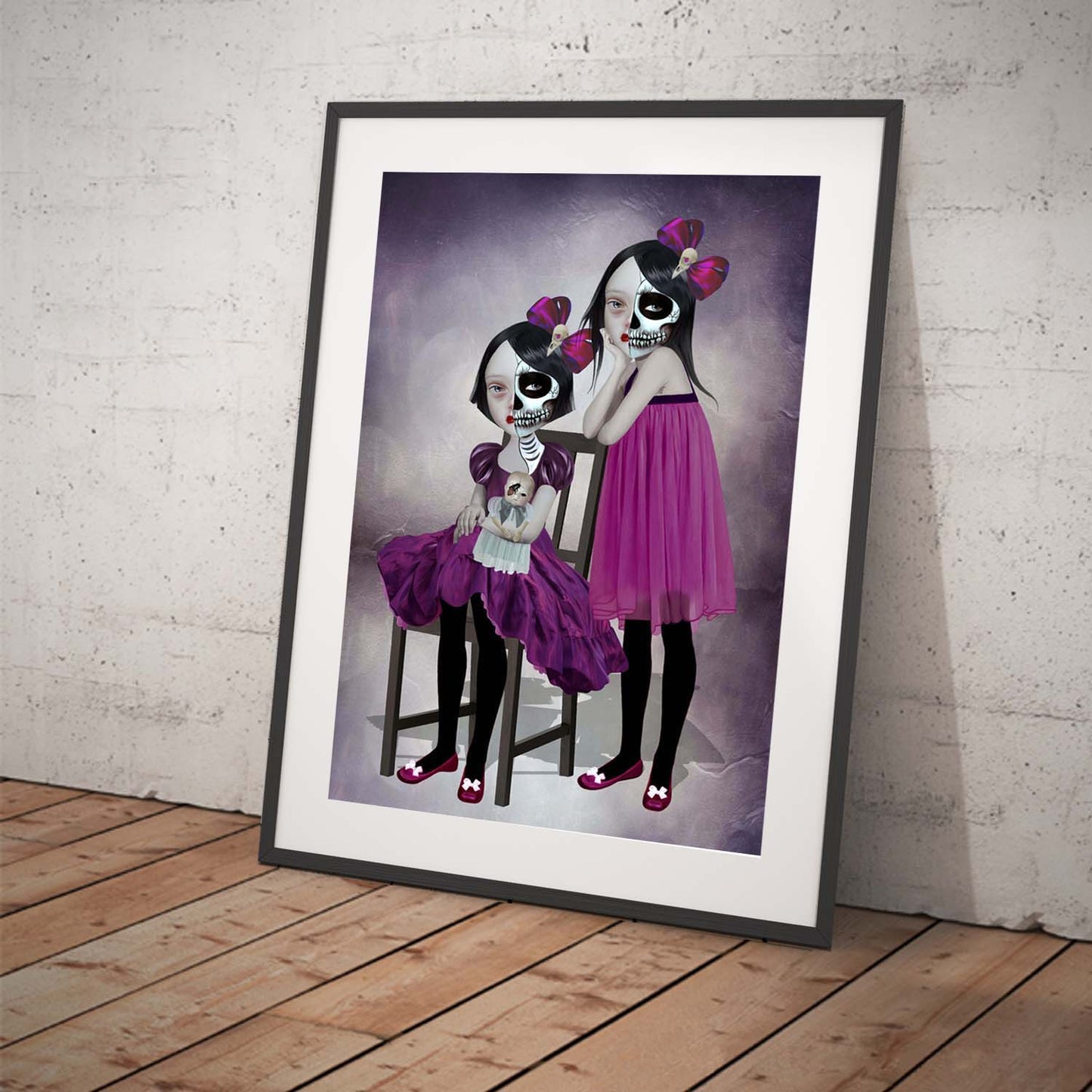 Art print featuring two sisters celebrating day of the dead. Displayed in a tilted frame for a stylish presentation. Perfect for creepy cute or gothic-themed decor.