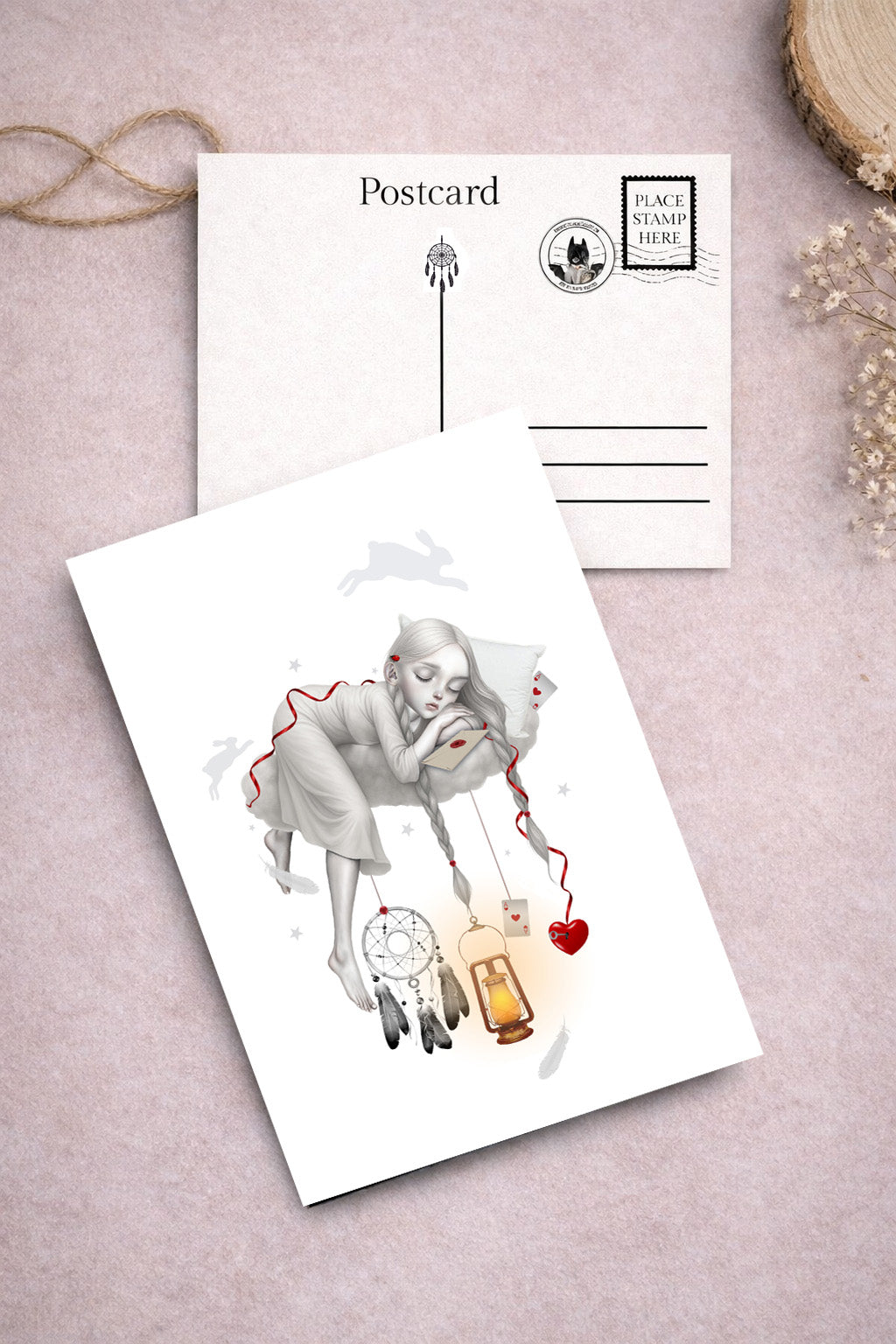 Dreamy art postcard on a textured surface with one featuring an illustration of a dreaming girl sleeping on a cloud.