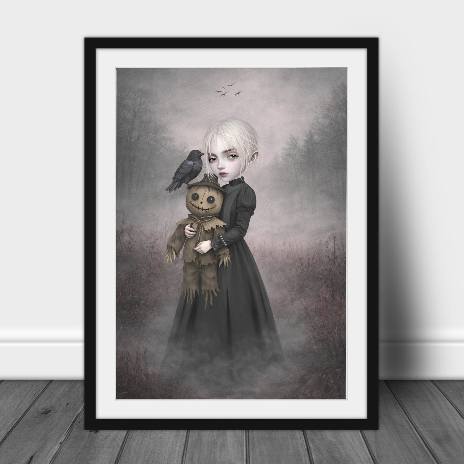 Eerie gothic art print in an A3 frame features a pale, platinum-haired girl clad in a sweeping, dark Victorian-style dress. In her arms, she cradles a stitched, creepy-cute scarecrow doll, while a solitary black crow perches quietly on its brimmed hat, watching a distant flock circle overhead. 