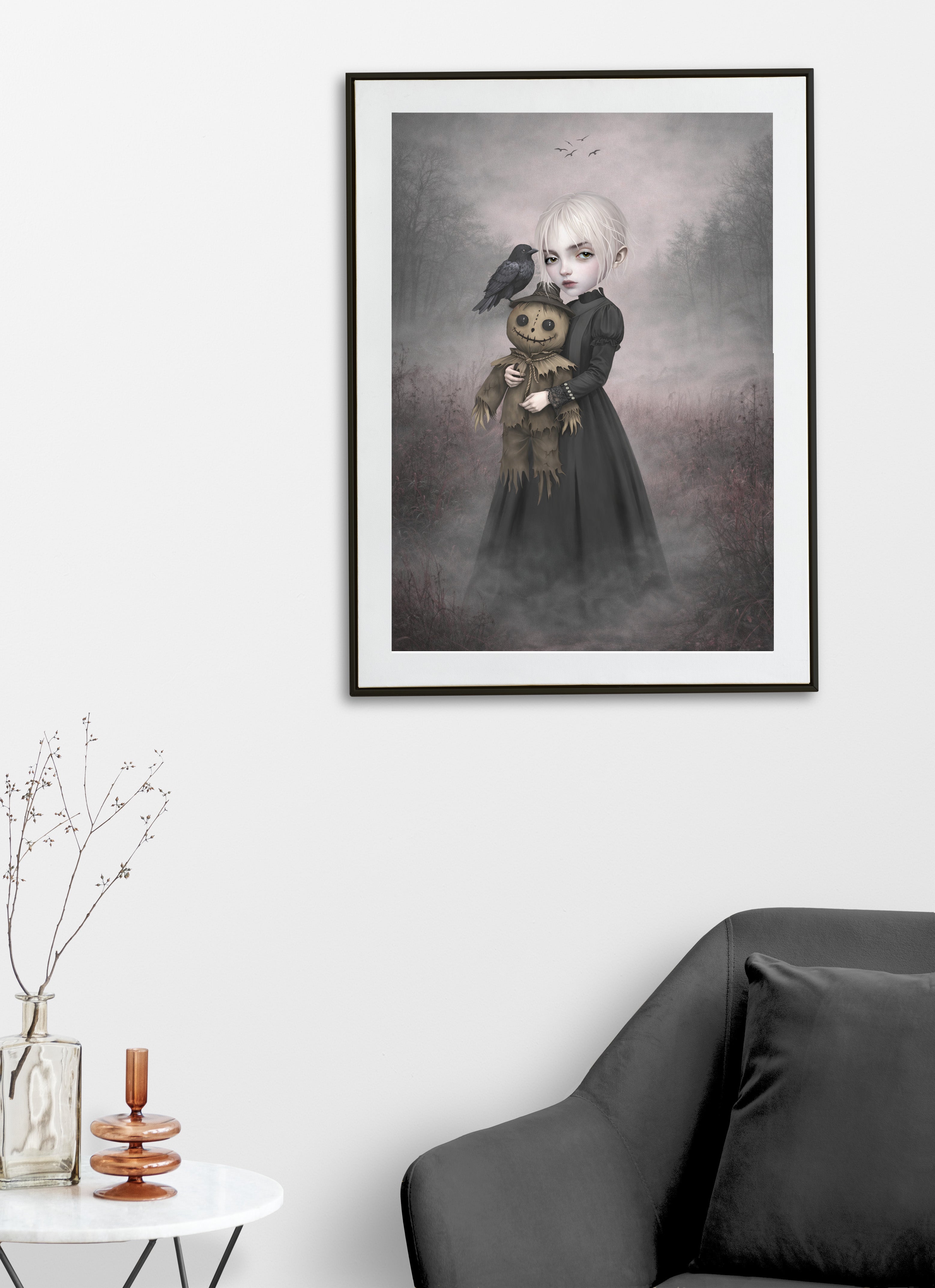 Eerie gothic art print on a living room wall display features a pale, platinum-haired girl clad in a sweeping, dark Victorian-style dress. In her arms, she cradles a stitched, creepy-cute scarecrow doll, while a solitary black crow perches quietly on its brimmed hat, watching a distant flock circle overhead. 