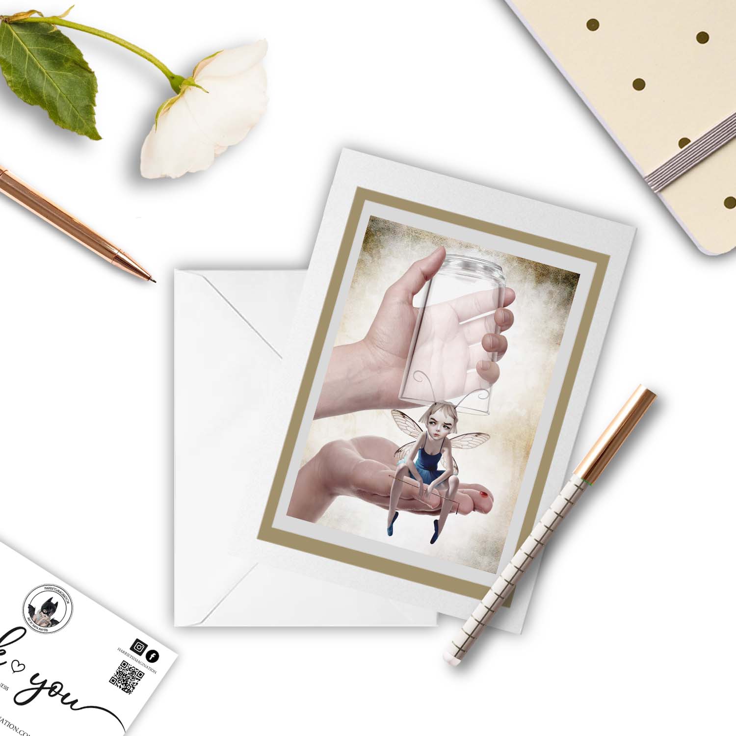Fairy greeting card displayed with a pen and notebook, featuring quirky lowbrow art of a fairy with a sewing needle