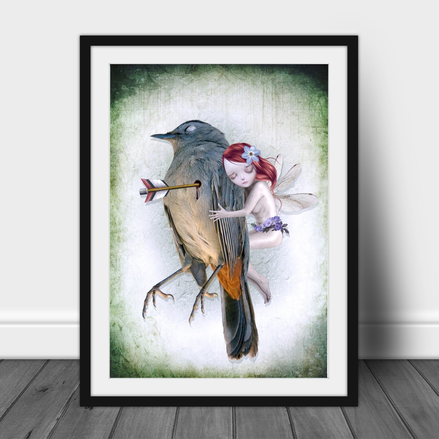 Framed artwork of a fairy hugging a wounded songbird with an arrow, against a light background.