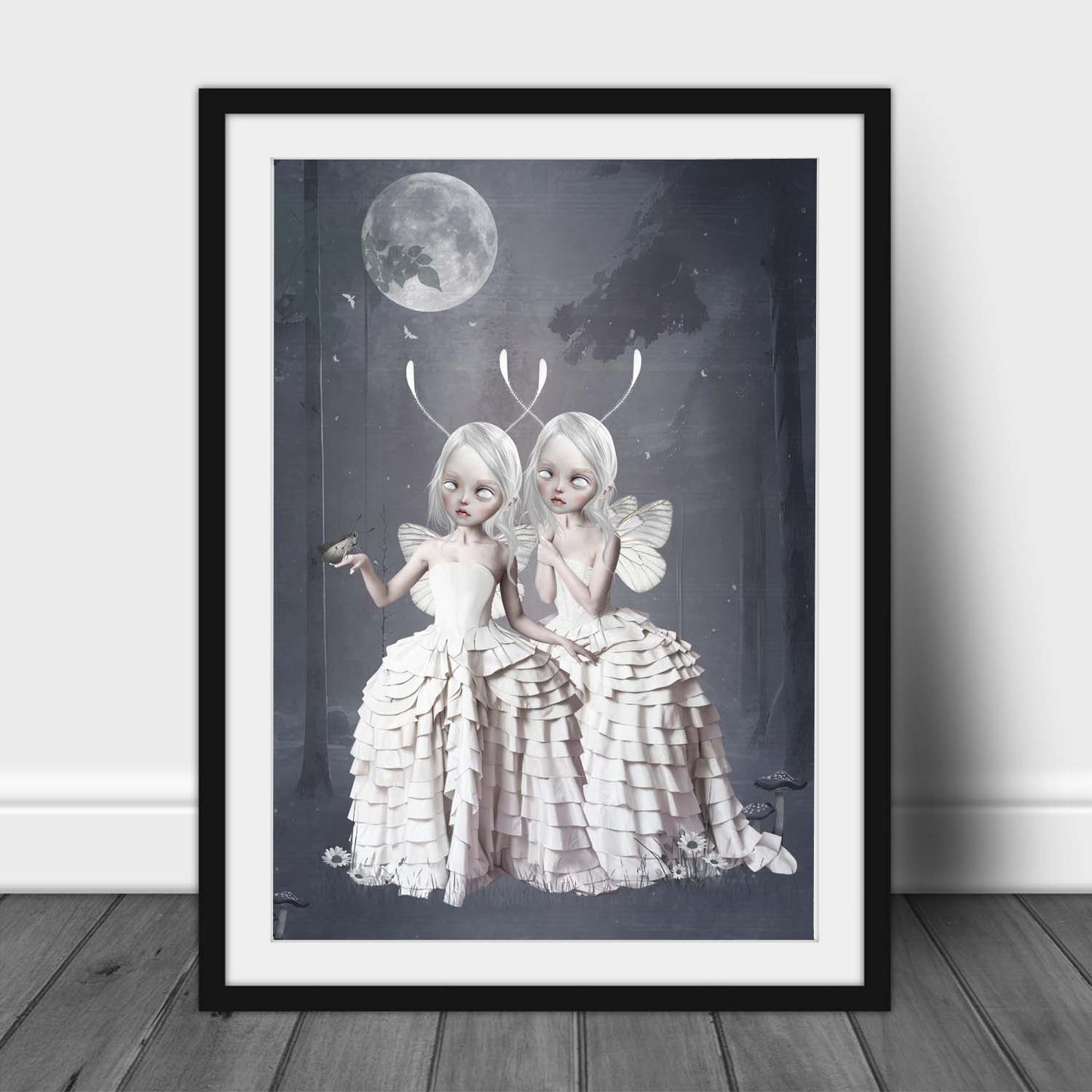 Framed Fantasy art print, image is  two Moth girls in an enchanted forest, with a moth gently landing on one moth girl's hand.