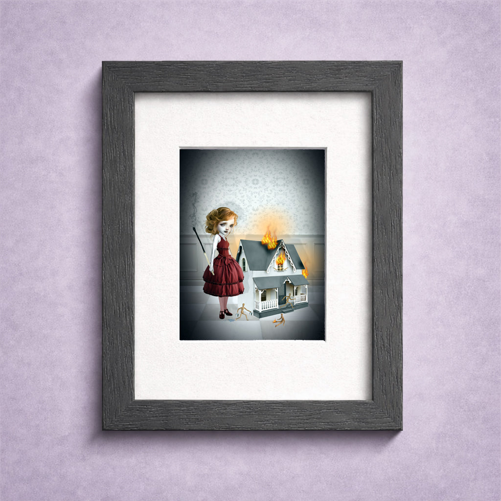 Framed artwork of a girl holding an oversized burnt matchstick stood beside  a toy house on fire.