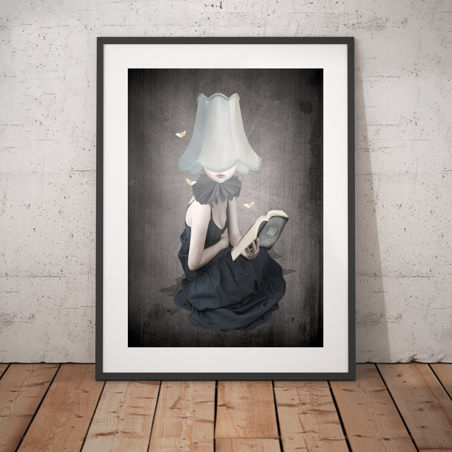 Framed Art Print. A girl, guided by the light of her lampshade, loses herself in the pages of a book. Surrounded by fluttering moths.
