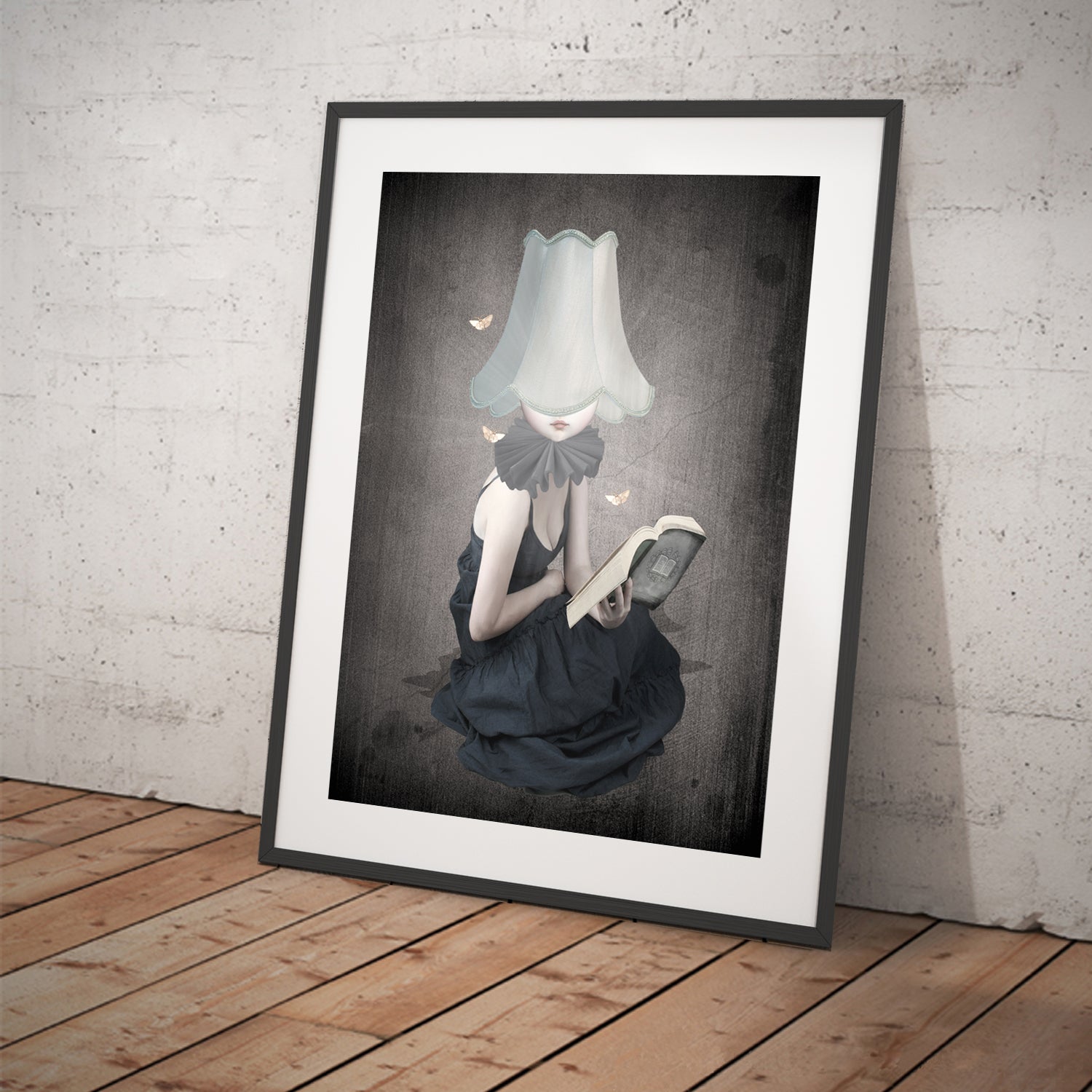 Moth Art Print in frame. A young girl, guided by the light of her lampshade, loses herself in the pages of a book. Surrounded by fluttering moths,