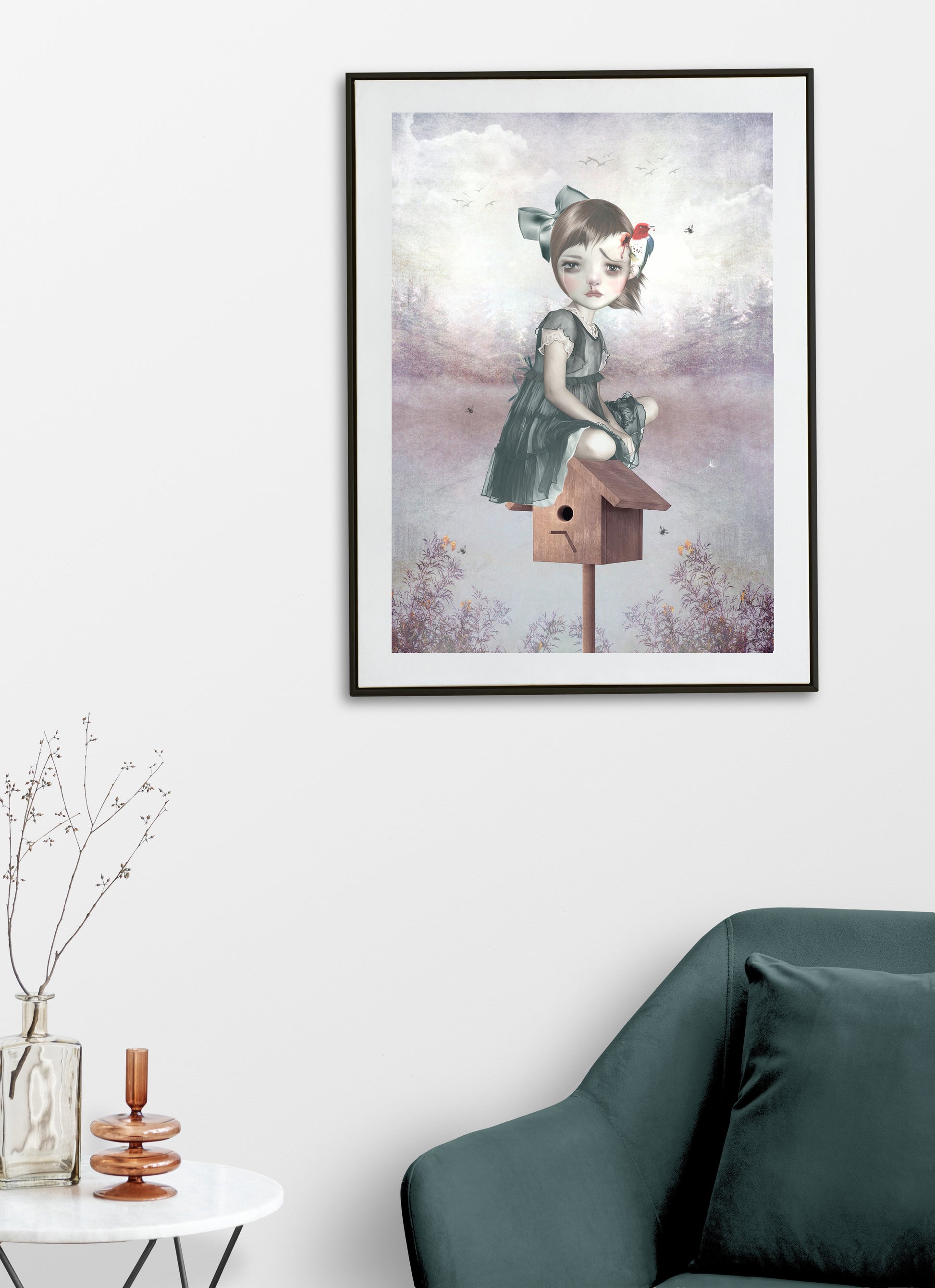 Framed surreal art print on a living room wall, showcasing a girl sitting on a birdhouse with a woodpecker pecking her head, adding a whimsical touch to the space.