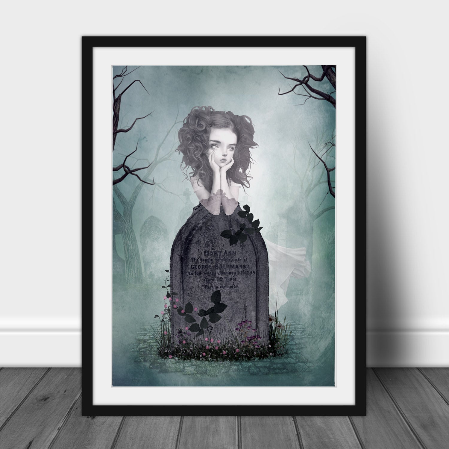 Framed artwork of a ghost girl by a tombstone in graveyard with a ghostly effect on a light blue background.