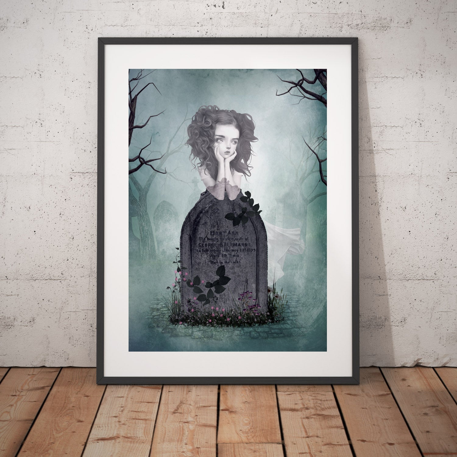 Ghost Girl art print in a black frame, standing against a white wall.