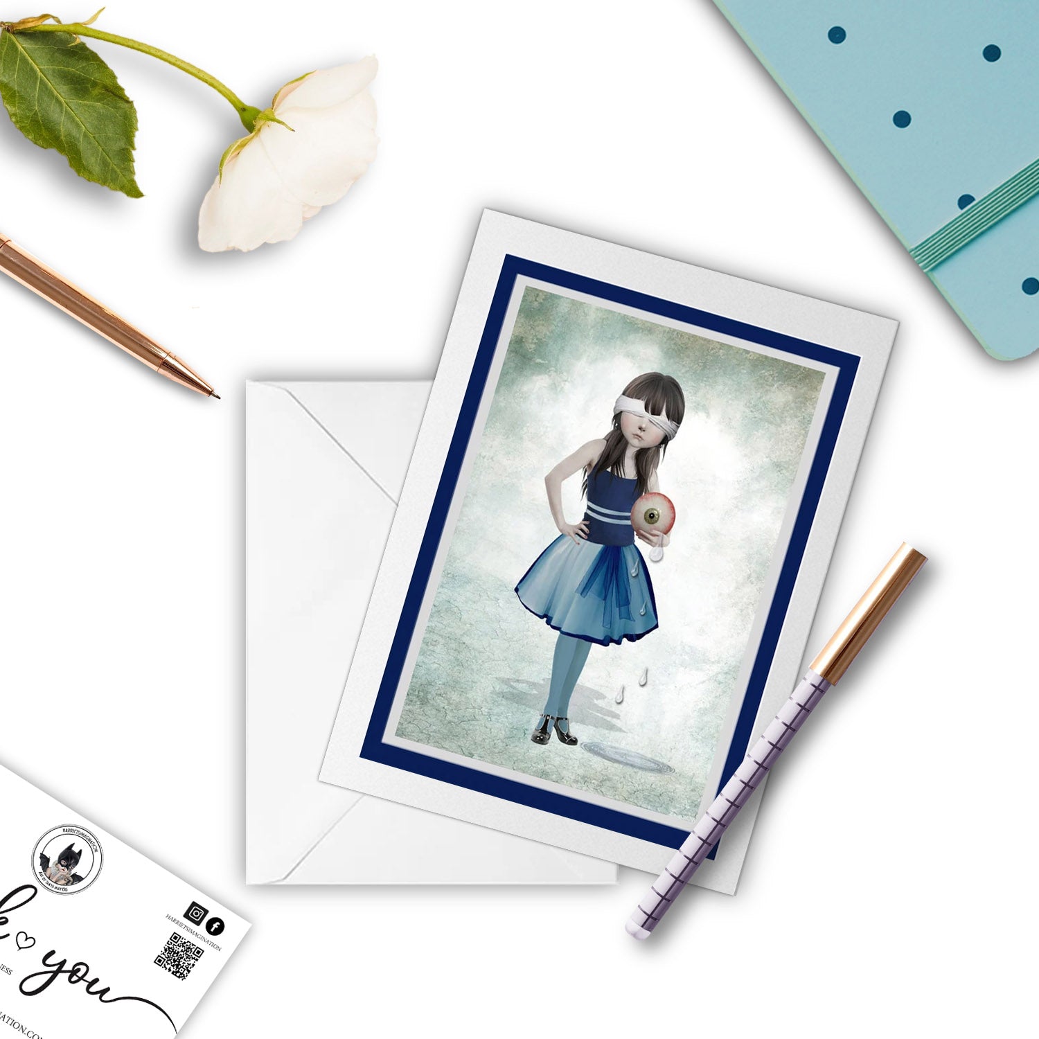 Girl and eyeball greeting card beside a notebook and pen – perfect for gifting or writing a quirky, poetic note.