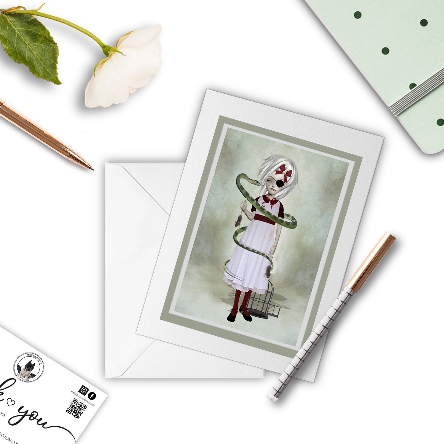 Girl and snake greeting card beside a notebook and pen – perfect for gifting or writing a dark, poetic note.
