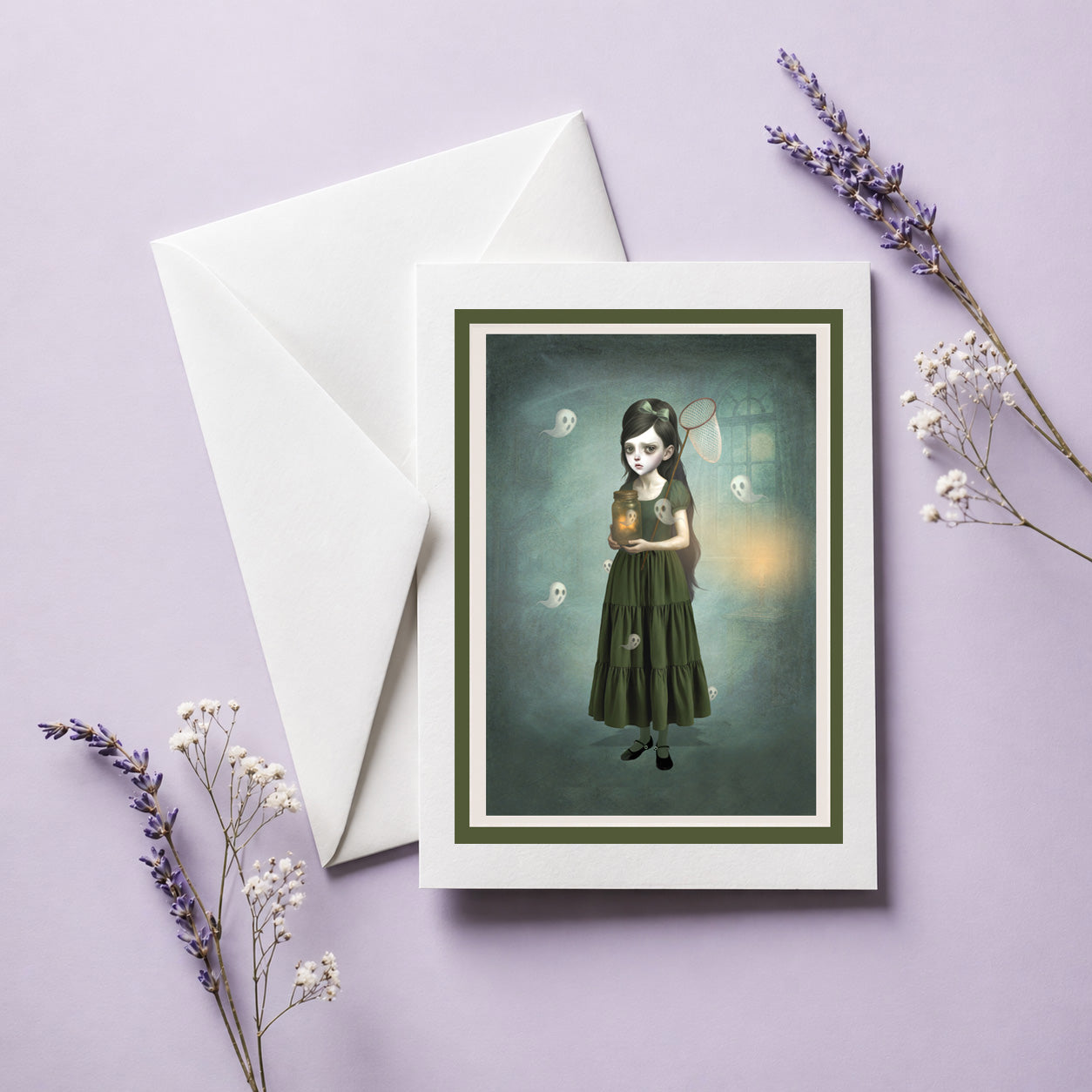 whimsical gothic greeting card features a girl catching ghosts in a jar, displayed on a lilac background.