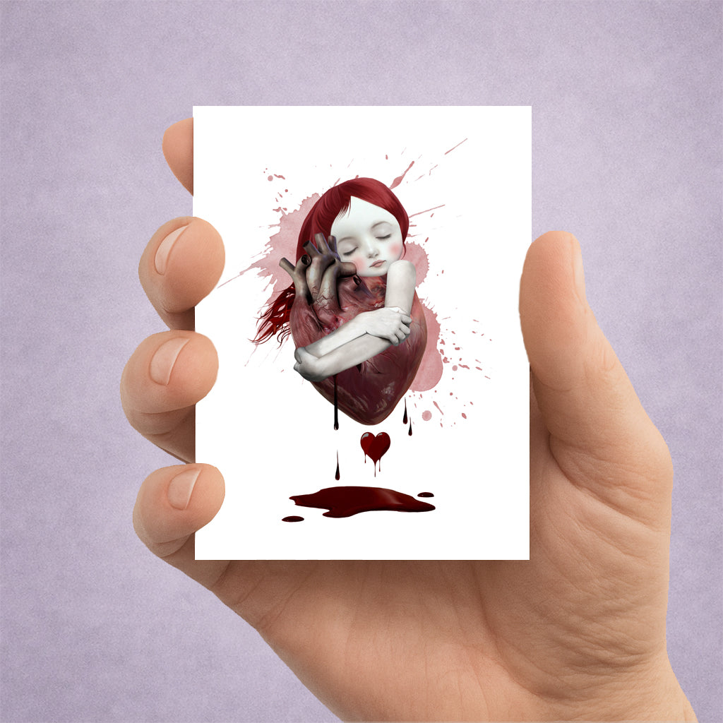 Hand holding an ACEO card with an artistic illustration of a woman embracing a heart with red hair against a purple background.