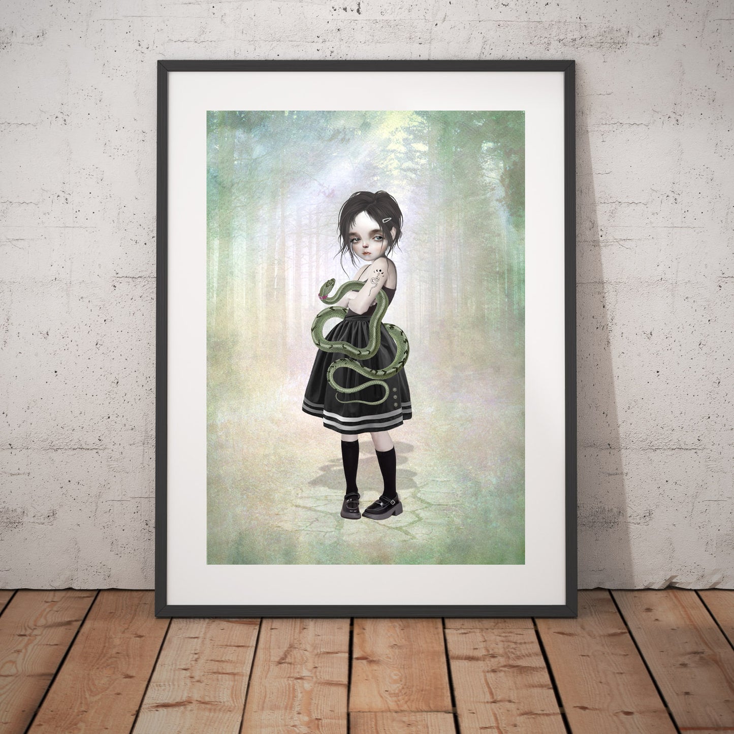 Girl and pet snake art print in a black frame, standing against a white wall.