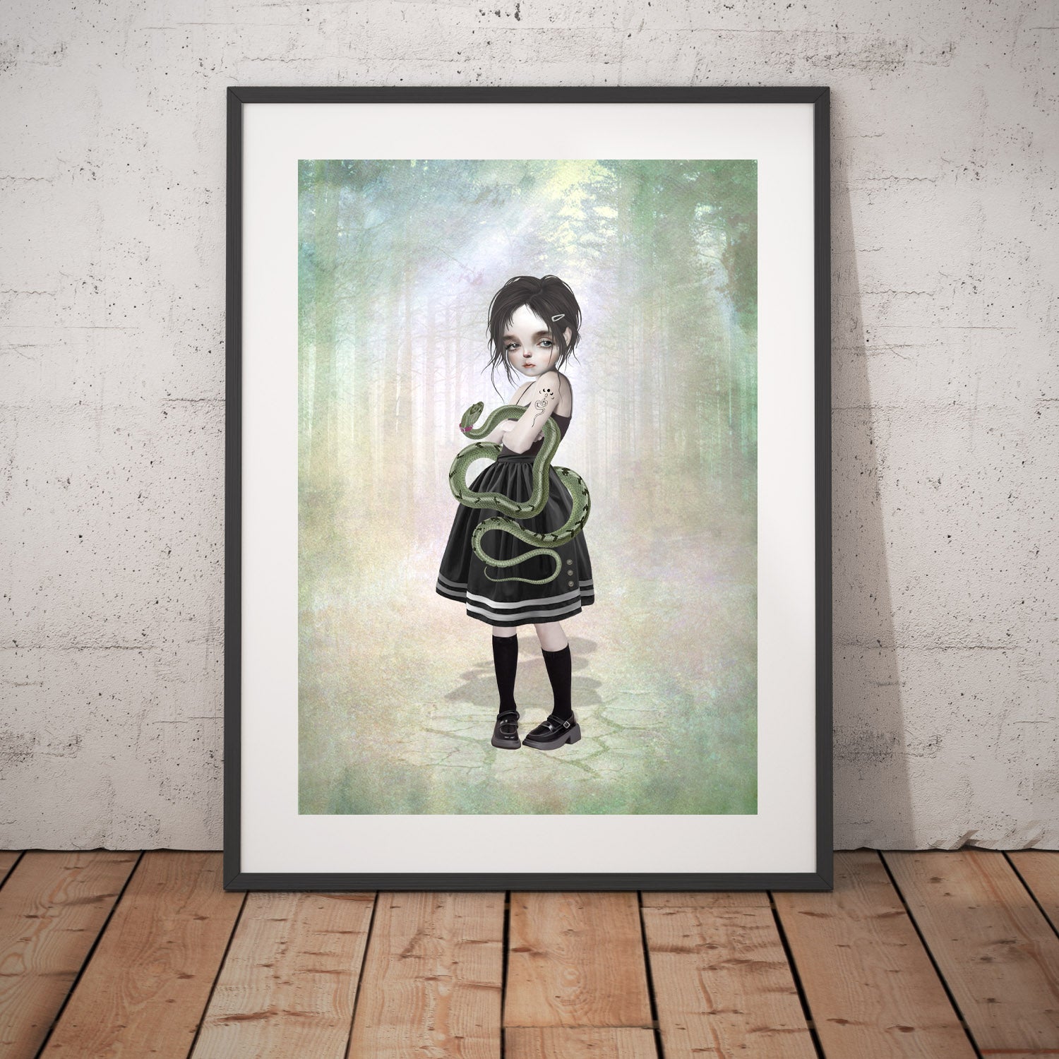 Girl and pet snake art print in a black frame, standing against a white wall.