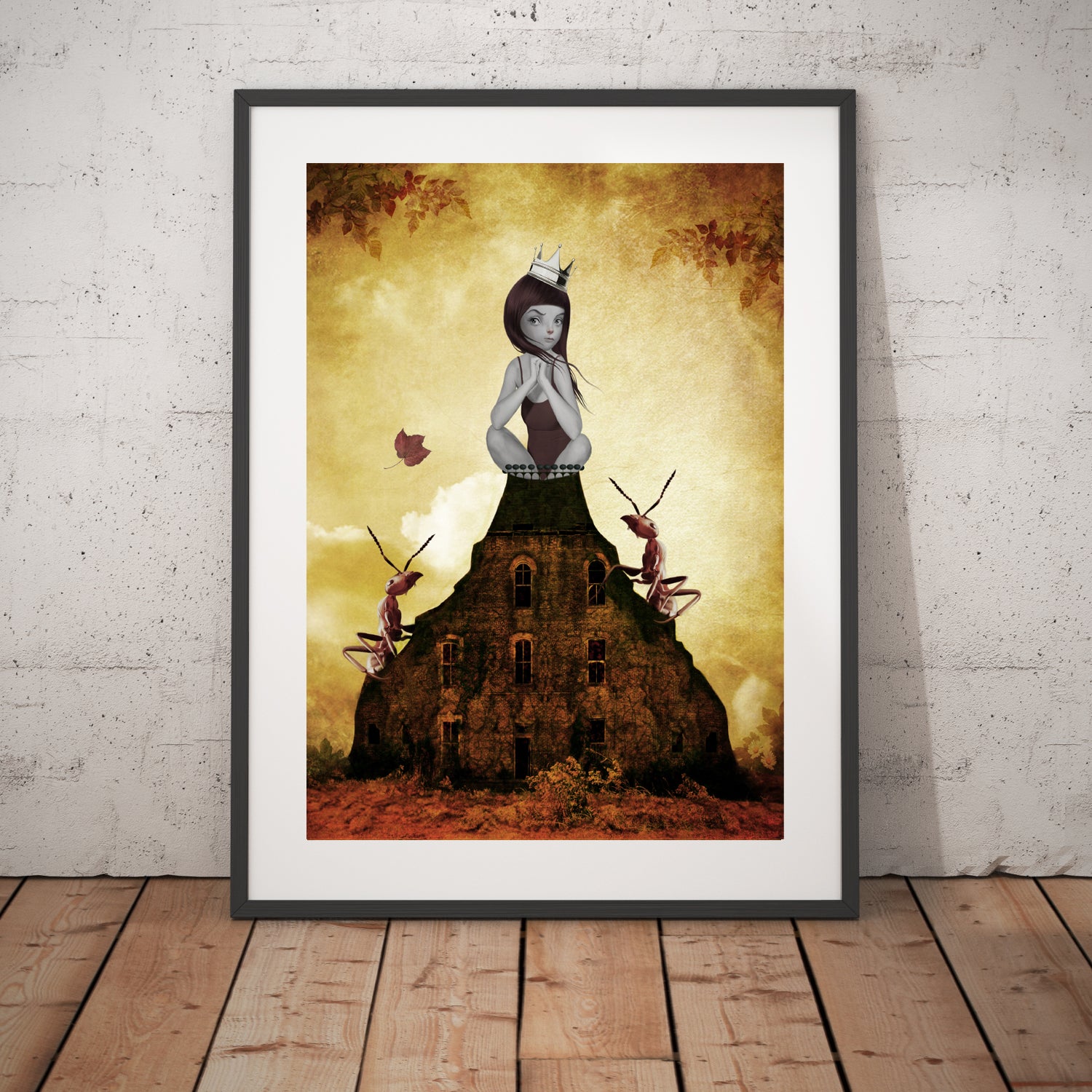 Girl and red ants art print in a black frame, standing against a white wall.