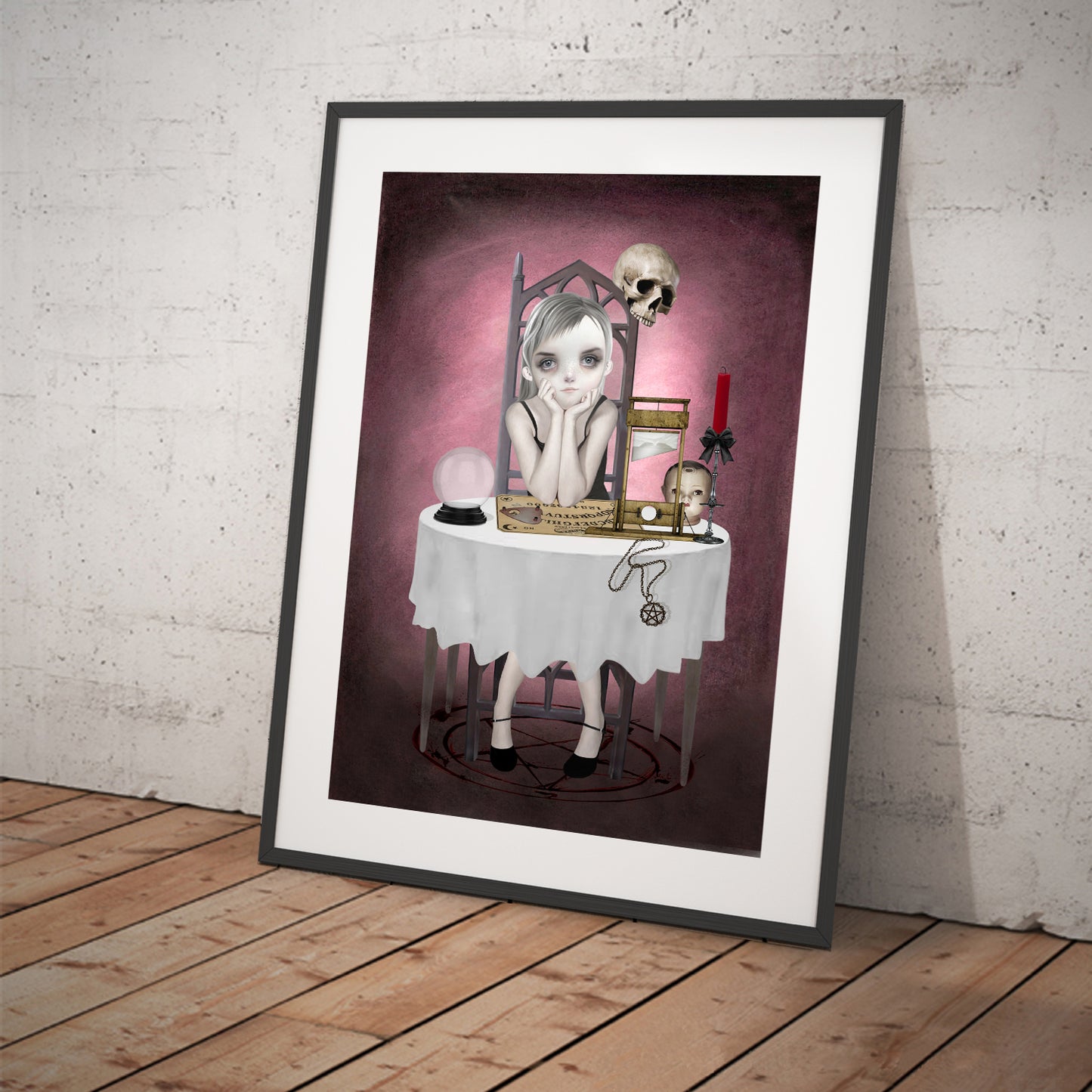 Art print featuring a goth girl and ouija board. Displayed in a tilted frame for a stylish presentation. Perfect for creepy cute or gothic-themed decor.