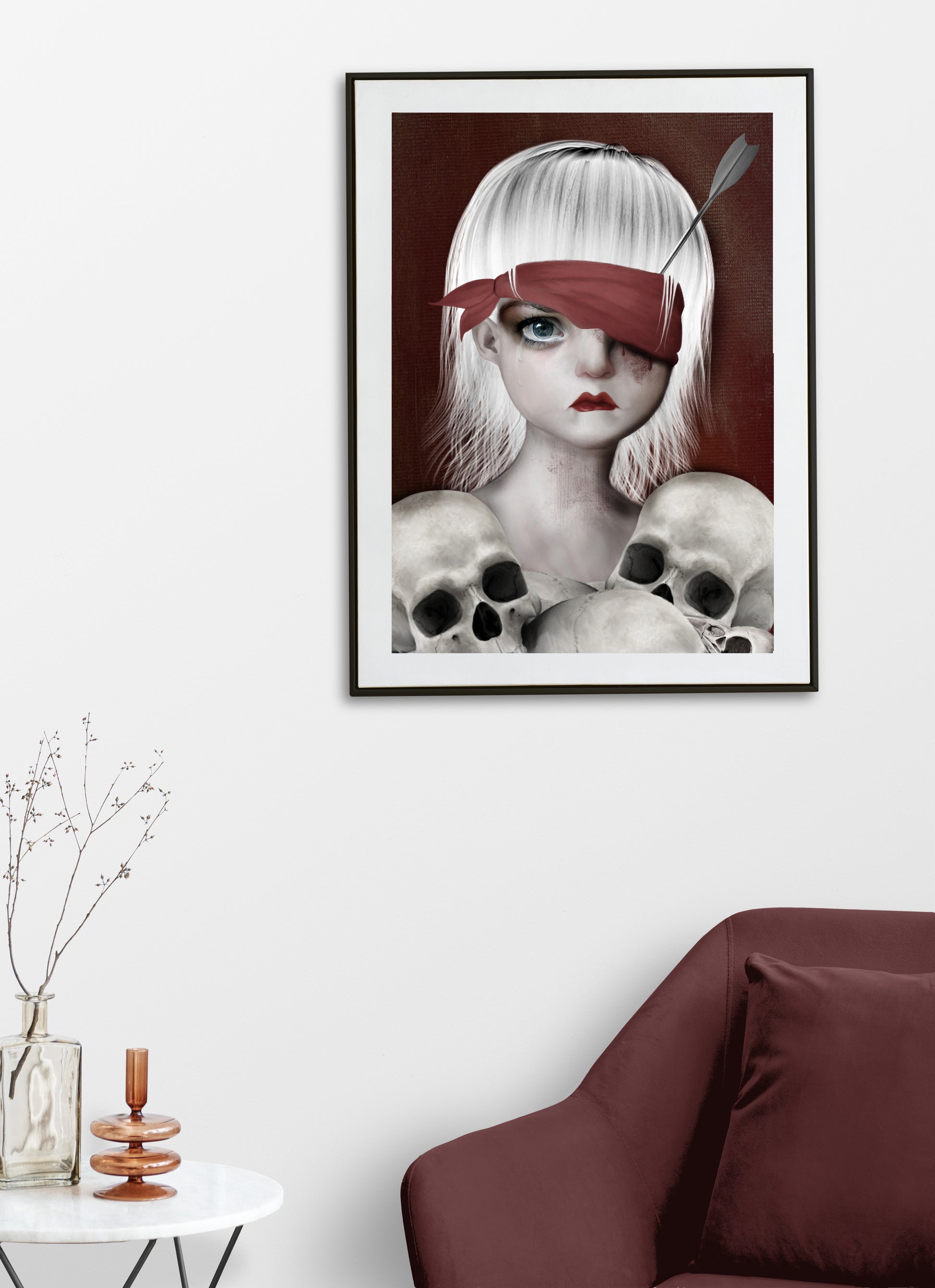 Macabre Art Print on living room wall. Featuring a girl with an arrow in her eye surrounded by human skulls