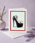 pop surrealism greeting card features a tattooed girl in an oversized black stiletto high heel.