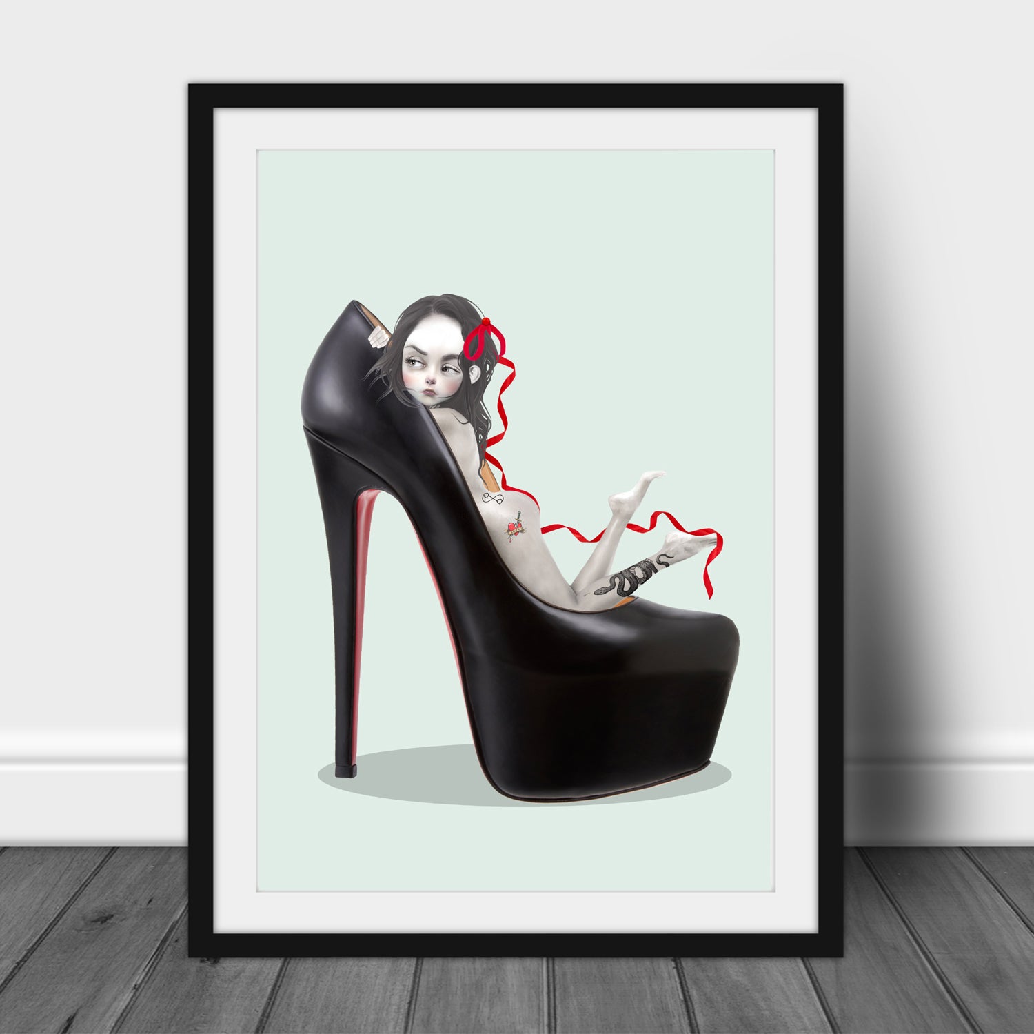 Framed artwork of a high-heeled shoe with a girl inside, on a light green background.