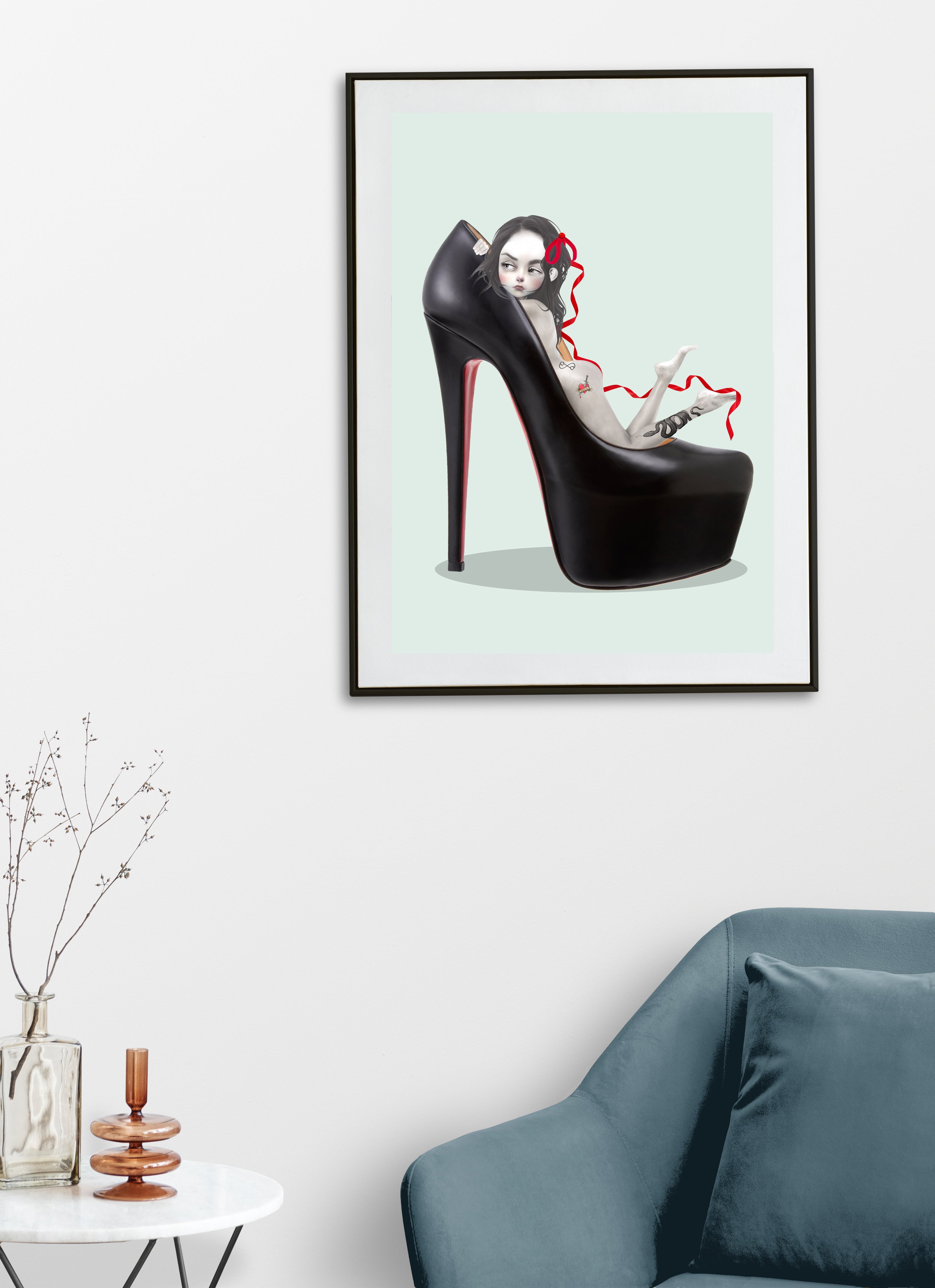 Framed artwork of a black high-heeled shoe with a girl inside on a light green background, displayed in a living room.