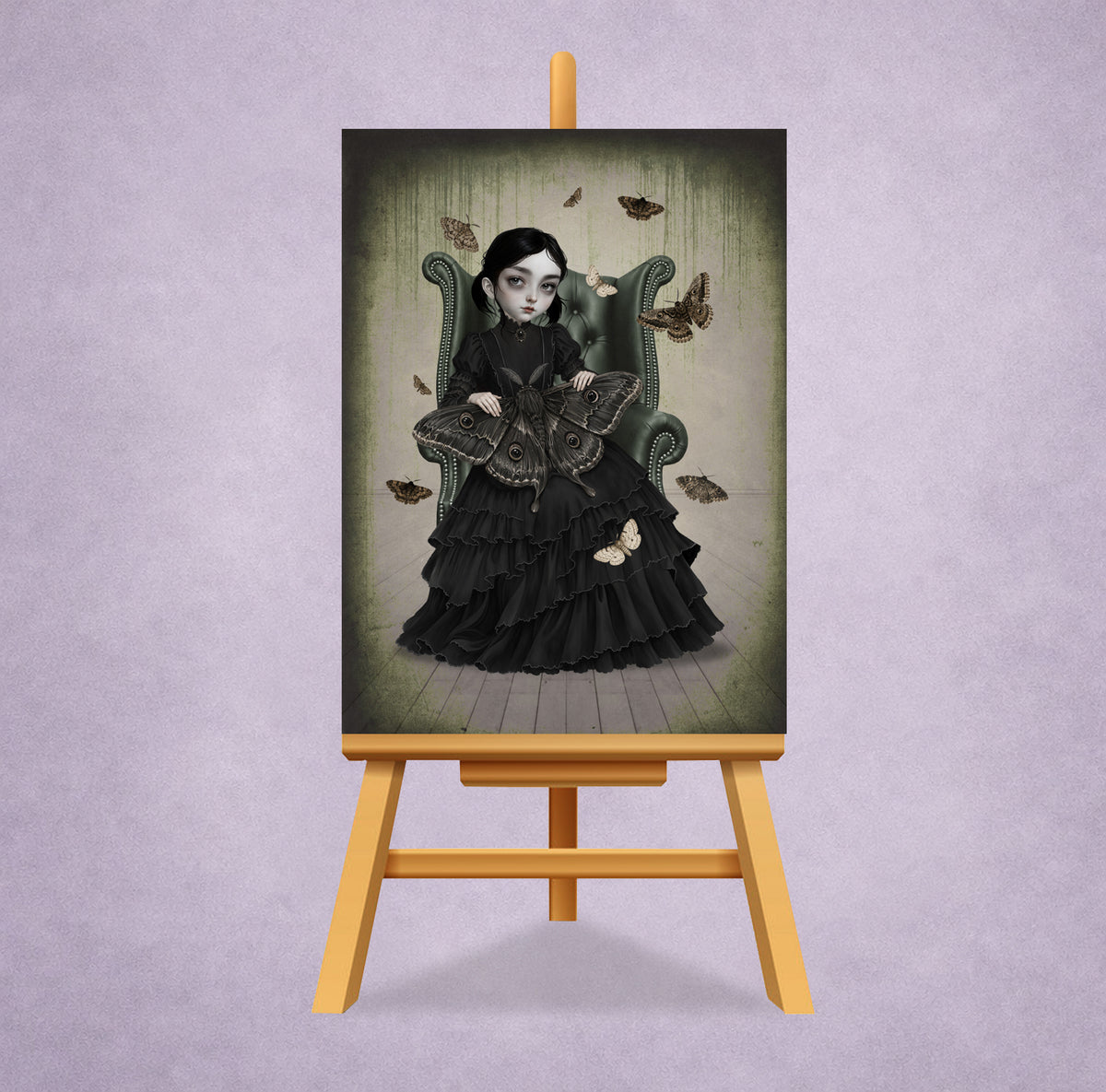 A 2.5x3.5 inch ACEO art trading card On a small display stand featuring a gothic girl in a black Victorian dress sitting in an armchair with giant moths.