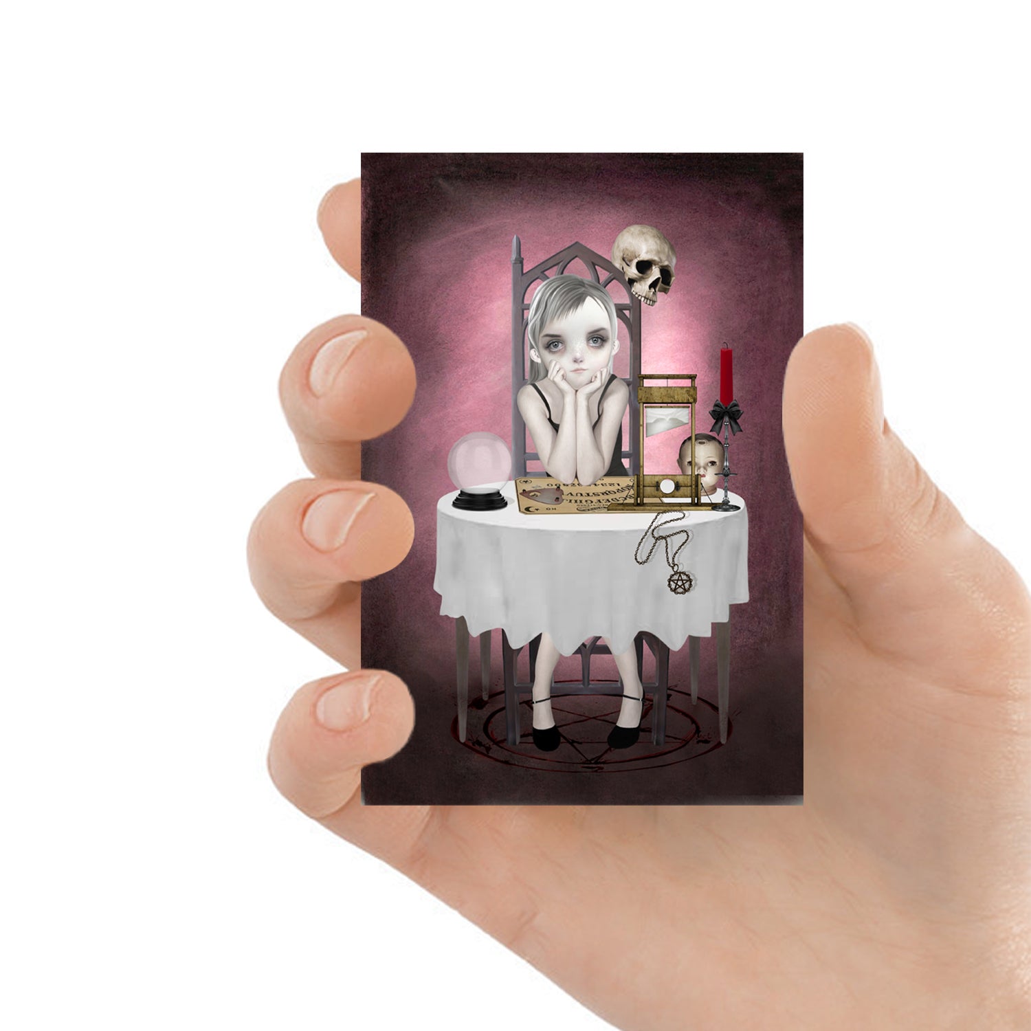 ACEO art card featuring a goth girl with ouija board, held in hand to showcase the miniature size and creepy cute design.