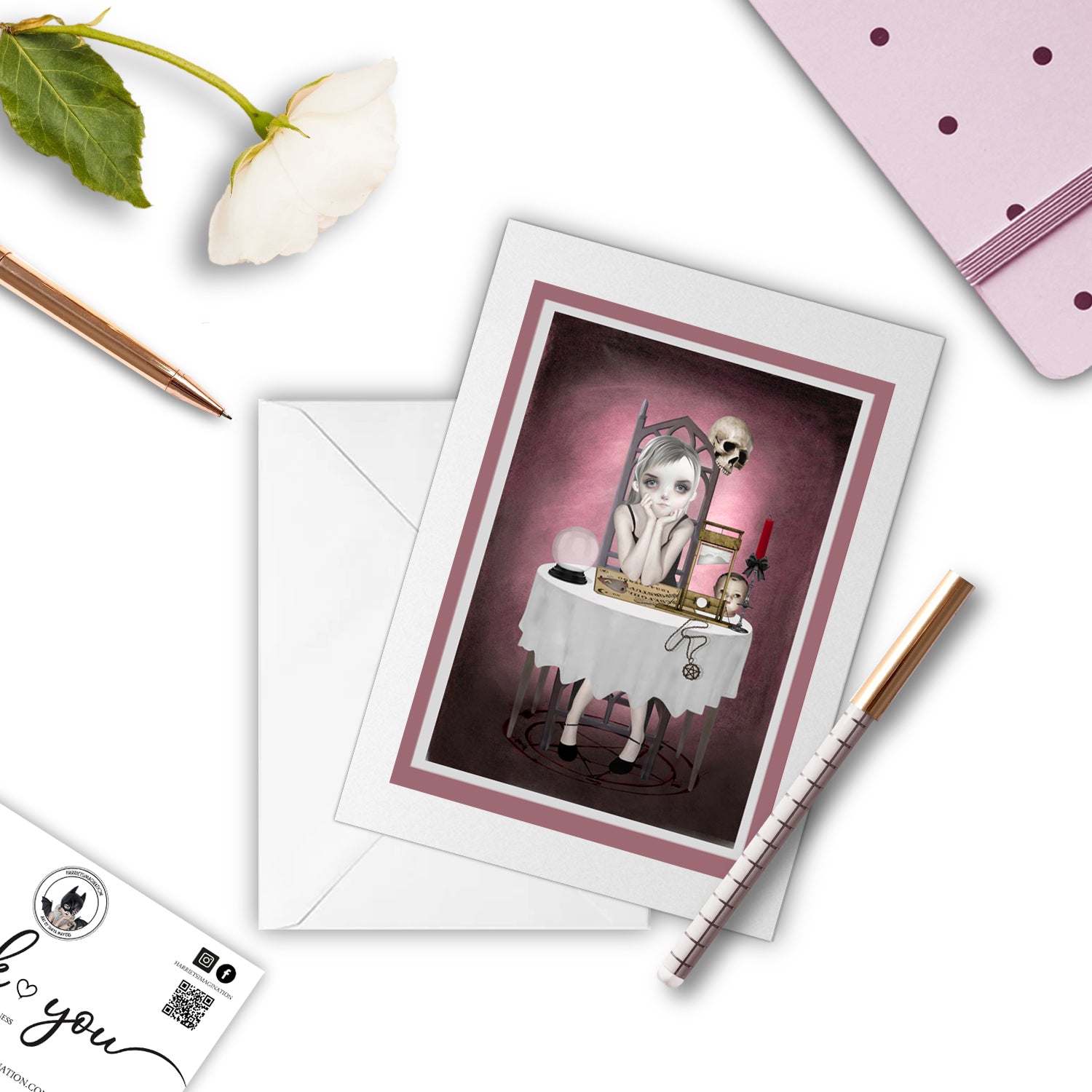 Goth Girl with ouija board greeting card beside a notebook and pen – perfect for gifting or writing a dark, poetic note.
