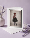 Creepy cute art greeting card with envelope featuring a surrealist portrait of a Victorian-style girl with spiderwebs over her eyes and black spiders crawling on her dress.